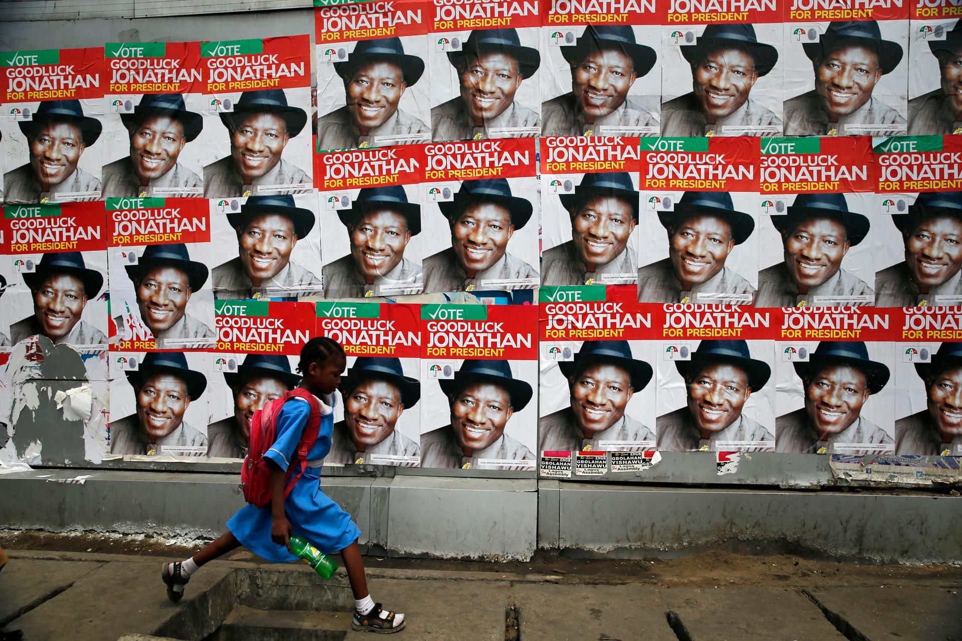 A schoolgirl walks past campaign posters in support of Nigeria's President Goodluck Jonathan along a road in Ikoyi district in Lagos.