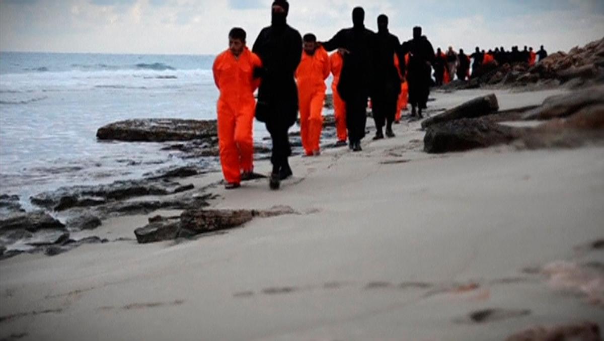 Men in orange jumpsuits purported to be Egyptian Christians held captive by the Islamic State (IS) are marched by armed men along a beach said to be near Tripoli, in this still image from an undated video made available on social media on February 15, 201