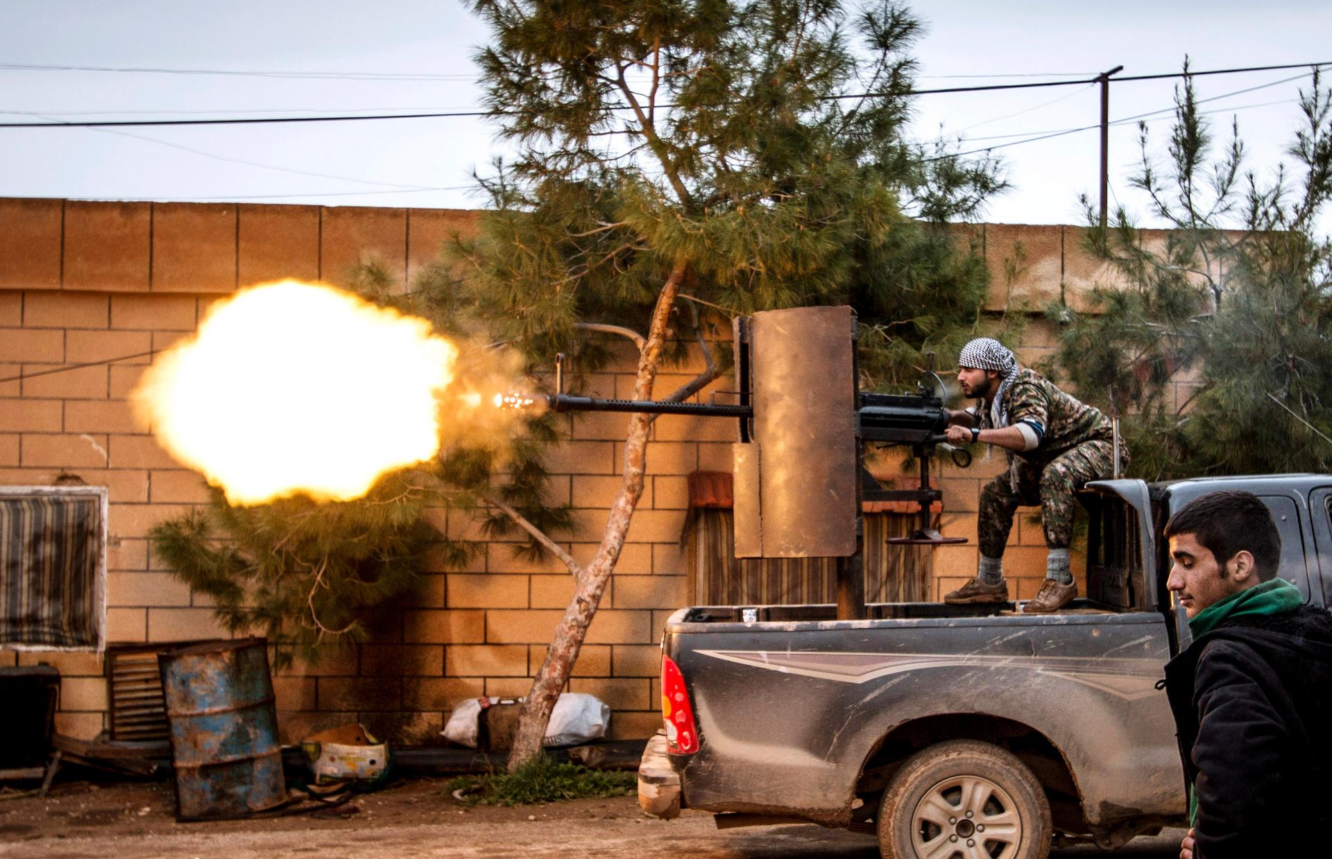 A fighter of the Kurdish People's Protection Units (YPG) fires an anti-aircraft weapon from Tel Tawil village in the direction of Islamic State fighters positioned in the countryside of the town of Tel Tamr in 2015.