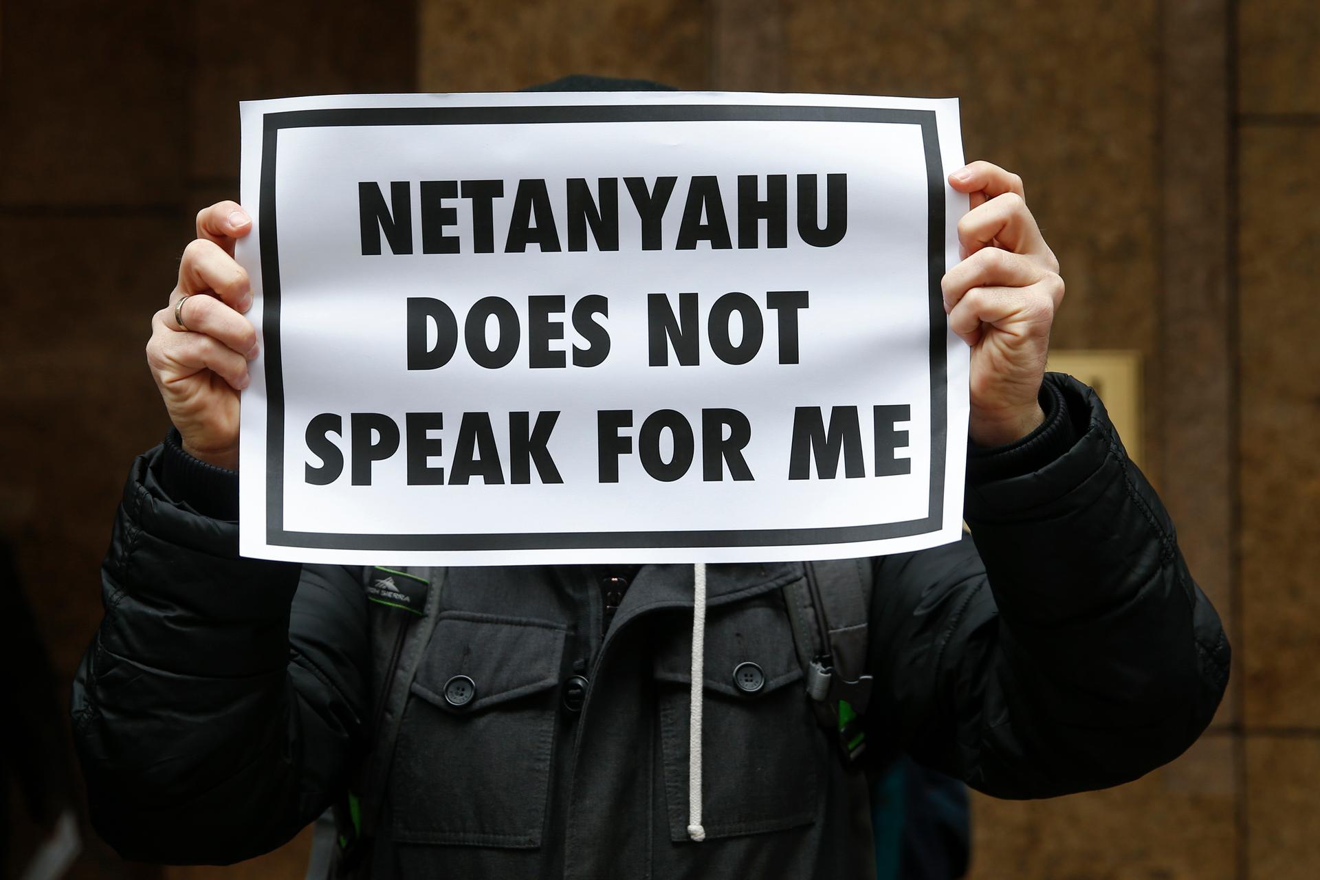 A demonstrator holds a sign during a rally near the Israeli Consulate in New York to protest Israeli Prime Minister Benjamin Netanyahu's speech in front on Congress.