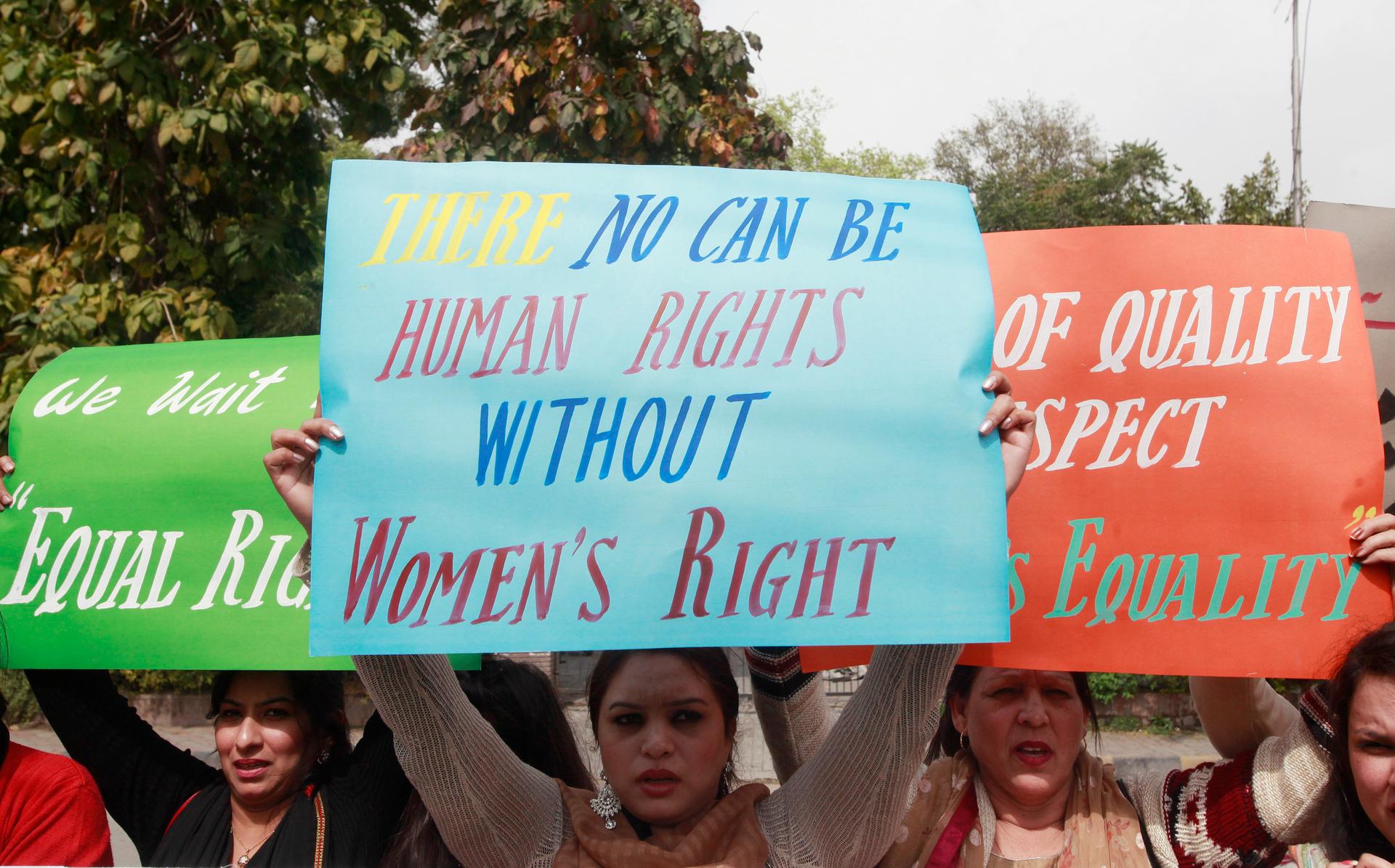 Women hold up signs during an International Women's Day rally in Lahore, March 8, 2015. Reuters/Mohsin Raza