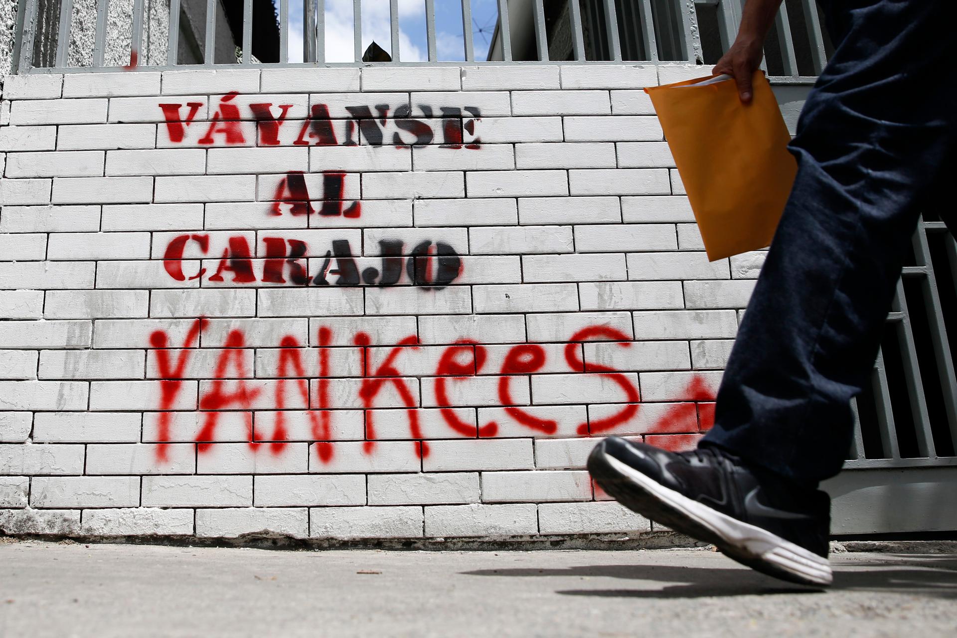 A man walks past graffiti which reads "Yankees, go to hell" in Caracas March 10, 2015. President Nicolas Maduro was seeking special decree powers from Venezuela's parliament on Tuesday in response to new US sanctions, drawing opposition protests of a powe