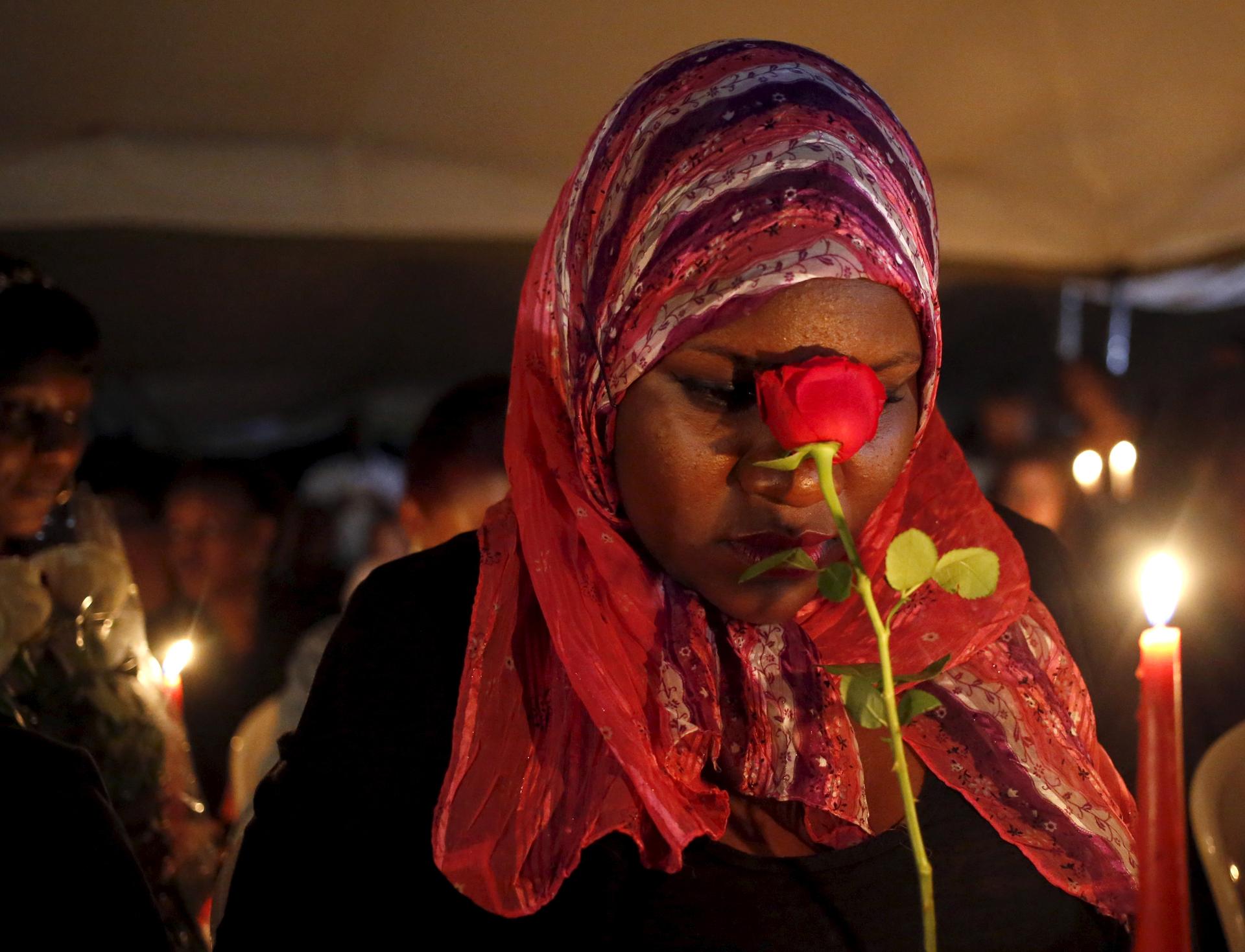 A woman holding a rose prays during a Nairobi memorial vigil following an attack by gunmen at Kenya's Garissa University College. 