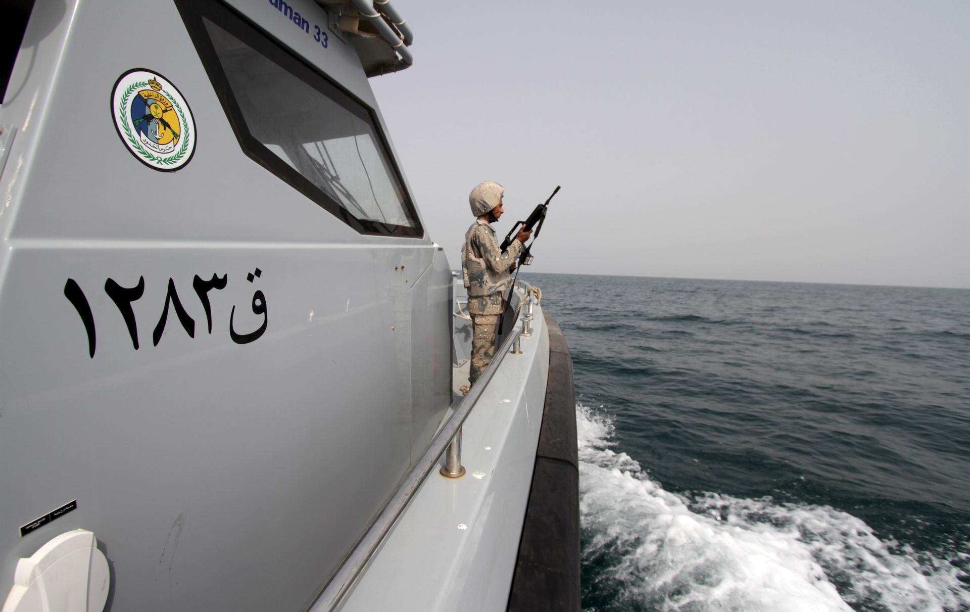 A Saudi border guard watches as he stands in a boat off the coast of the Red Sea on Saudi Arabia's maritime border with Yemen, near Jizan April 8, 2015