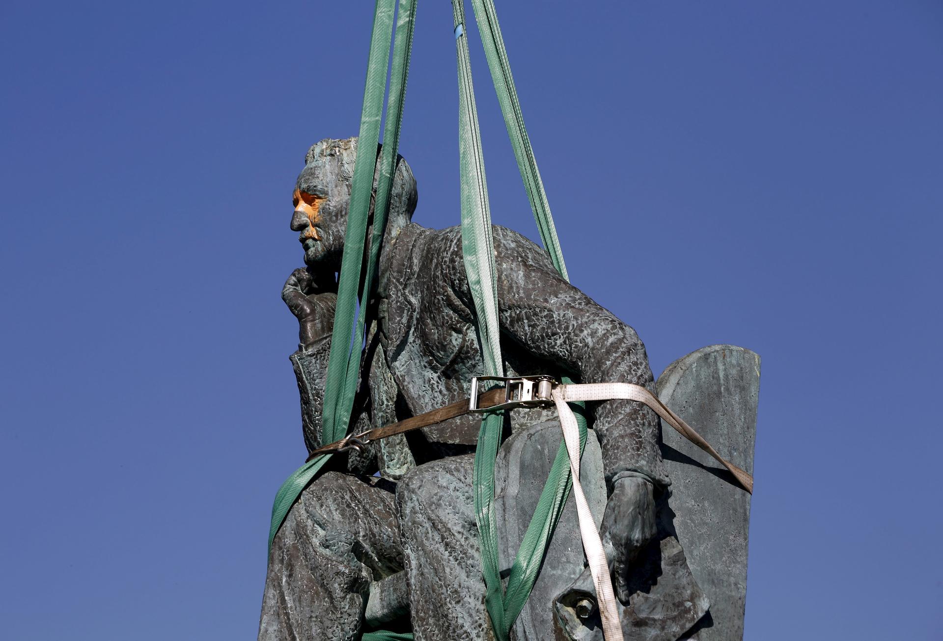 The statue of Cecil John Rhodes is bound by straps as it awaits removal from the University of Cape Town (UCT), April 9, 2015. UCT's Council voted on Wednesday to remove of the statue of the former Cape Colony governor, after protests by students