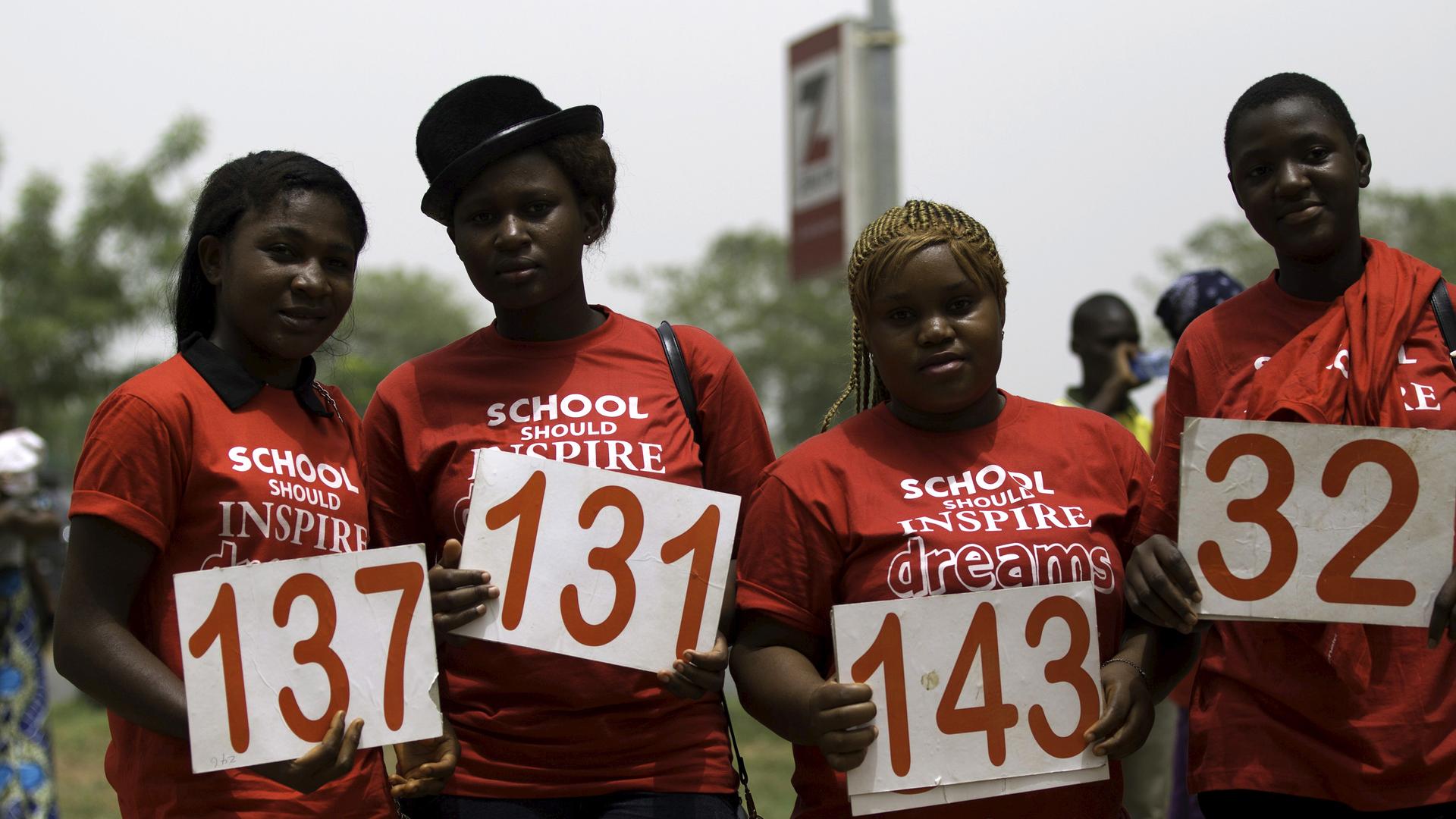 Students pose with placards as they join a march to mark the one-year anniversary of the mass kidnapping of more than 200 schoolgirls from a secondary school in Chibok by Boko Haram militants, in Abuja April 14, 2015.