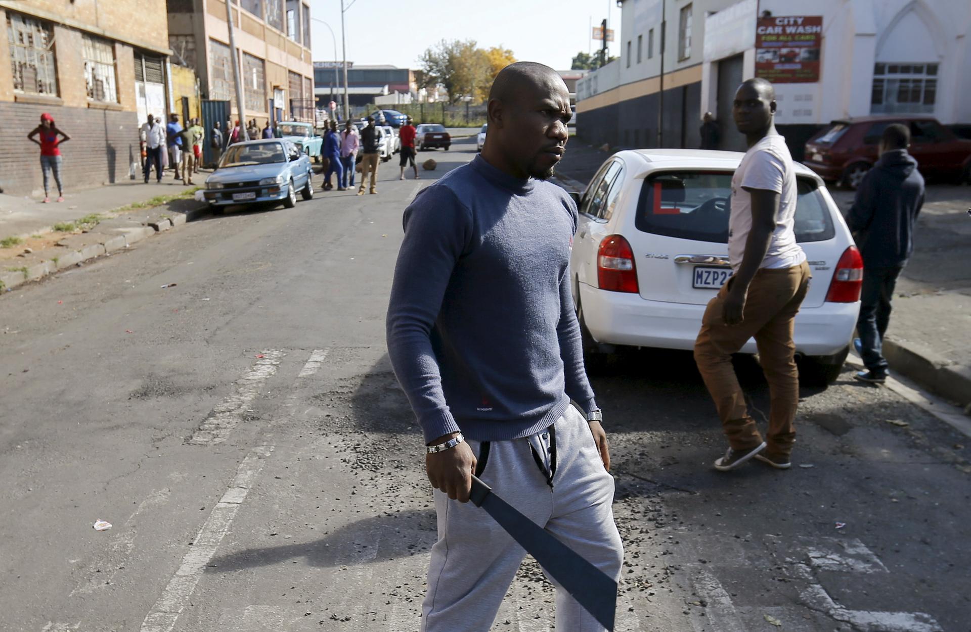 An African immigrant holds a machete in Johannesburg, South Africa. Immigrants have complained about a lack of police protection and some have started to arm themselves.