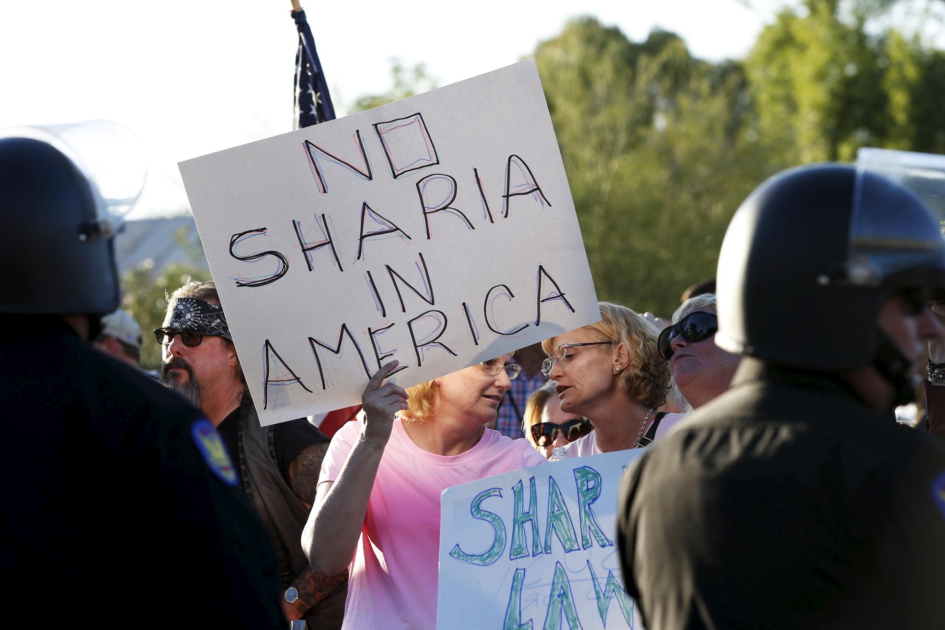Anti-Muslim protesters at a rally in Phoenix, Arizona on May 29, 2015 pointed to Islamic sharia law as a problem for the United States. The sentiment is said to be a driving force behind failed legislation in Texas to ban foreign laws in American courts. 