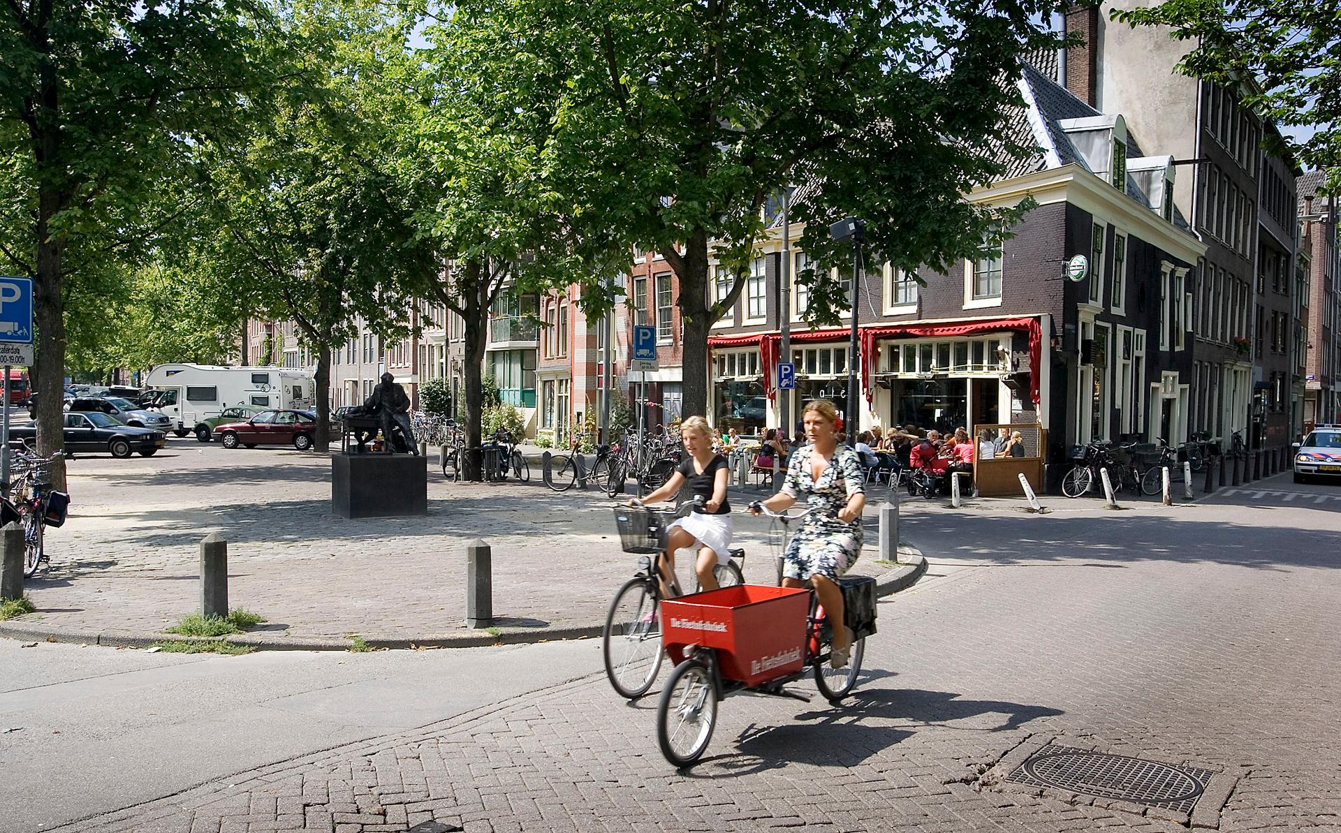 Two women ride their bicycles on the Lindengracht market in Amsterdam in this snapshot dating to August 2004. 