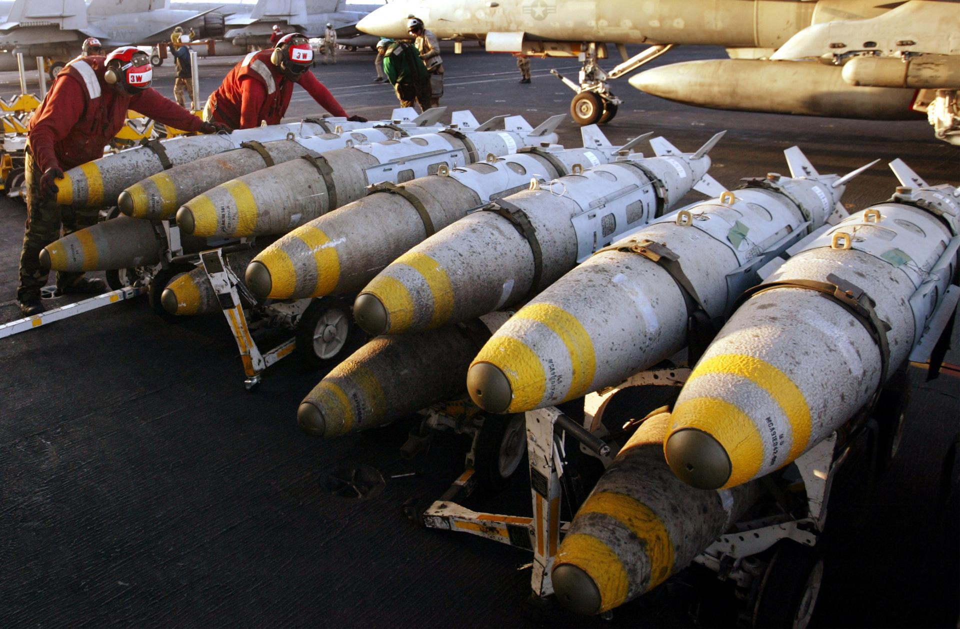 Aviation ordinancemen organize 1000 pound MK-83 JDAM (Joint Direct Attack Munition) bombs on their racks on the flight deck of the USS Kitty Hawk aircraft carrier in this archival photo taken in the northern Persian Gulf March 18, 2003. 
