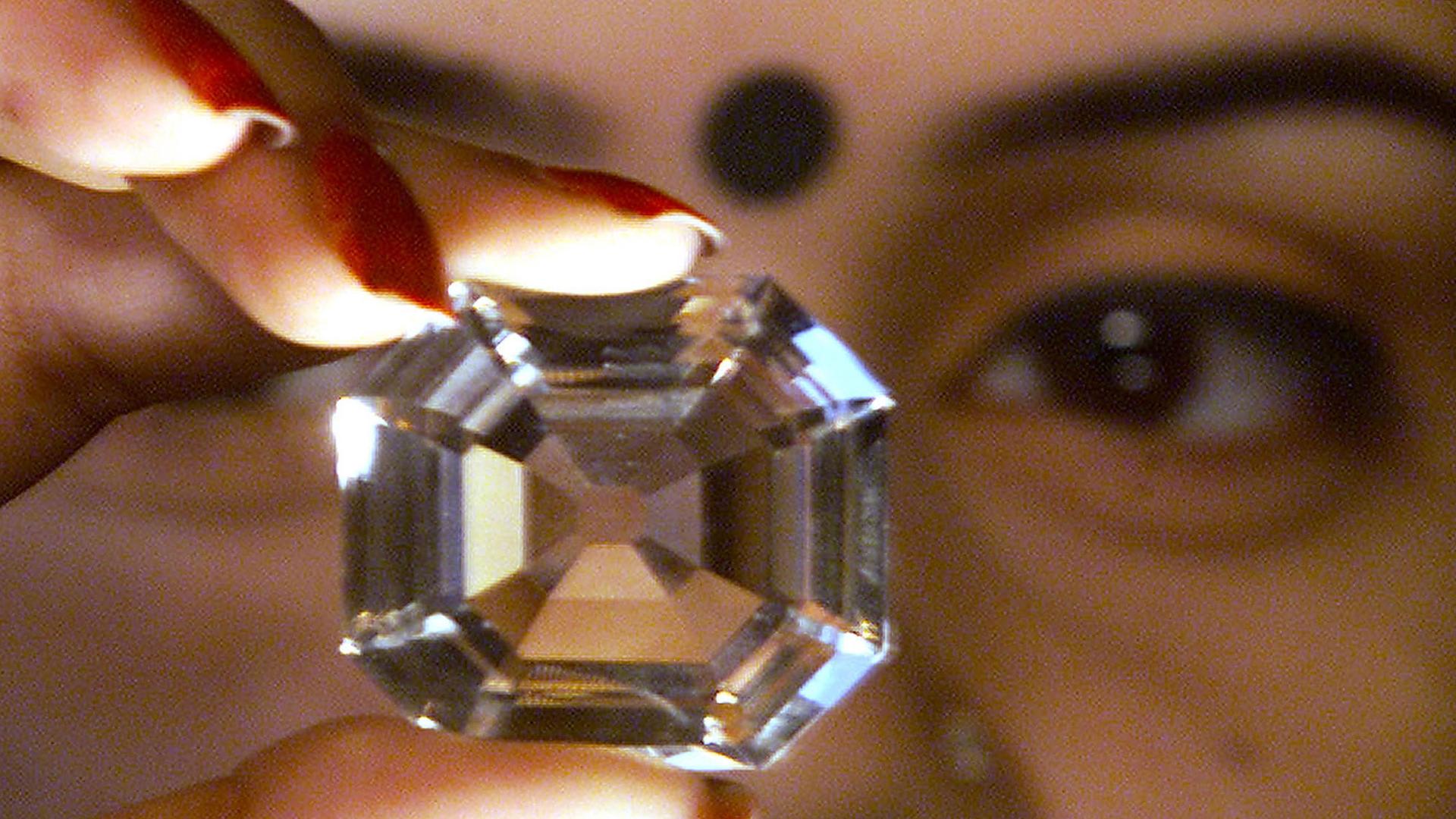 A woman holds a replica of the Koh-i-Noor diamond, during a diamond exhibition in Kolkata in 2002.