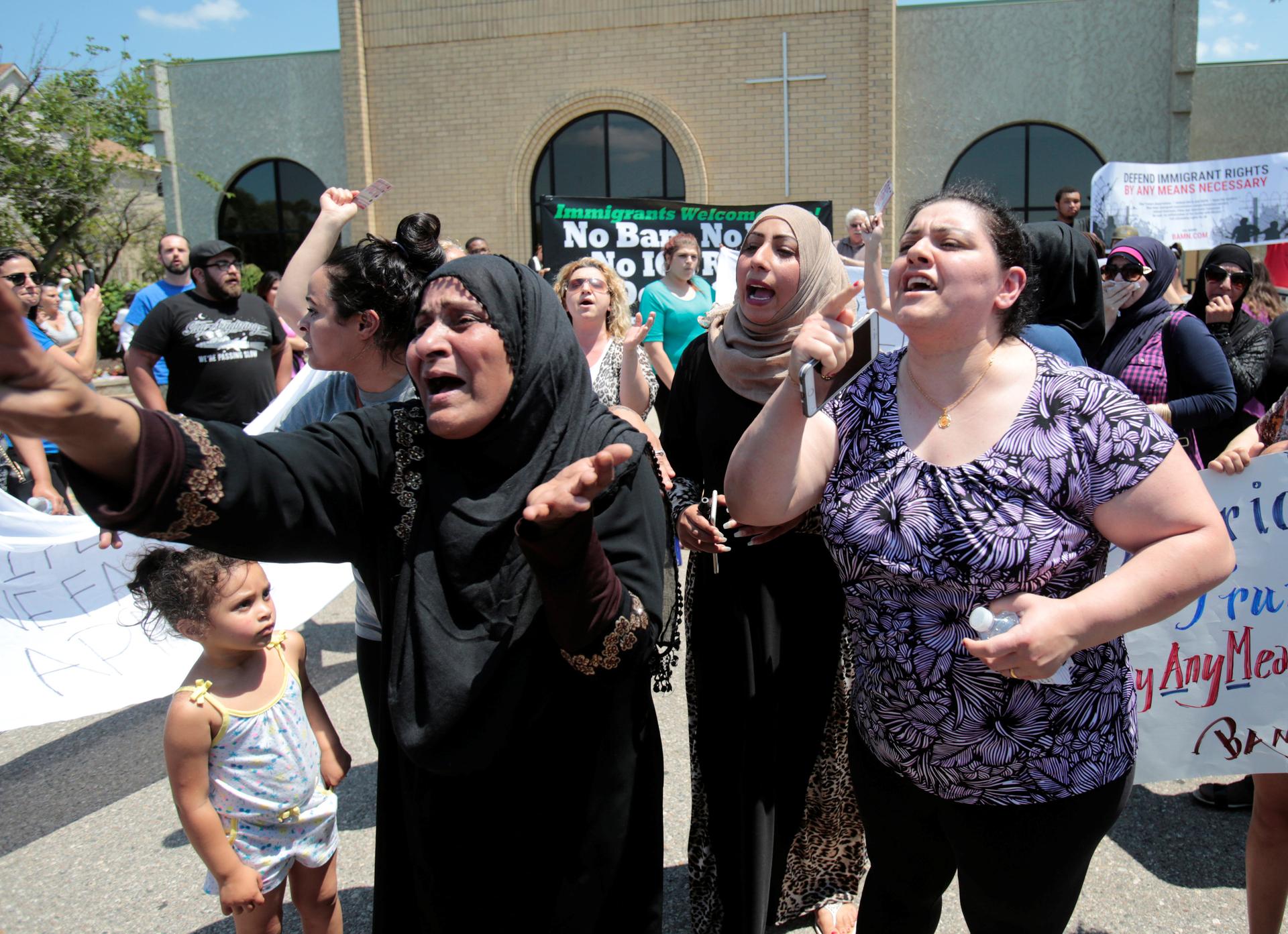 A group of women react as they talk about family members seized on Sunday by Immigration and Customs Enforcement agents during a rally outside the Mother of God Catholic Chaldean church in Southfield, Michigan, U.S., June 12, 2017.