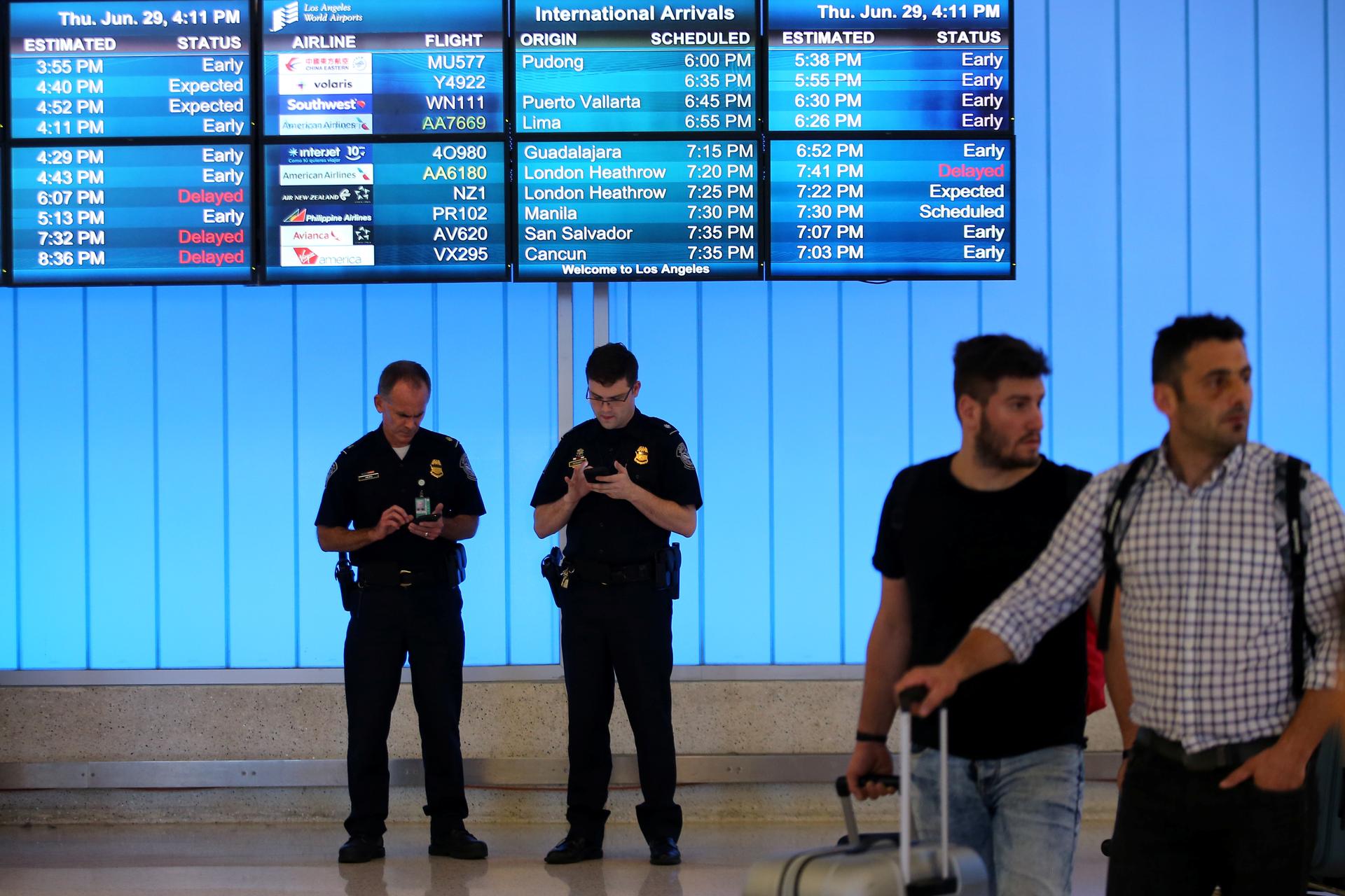 US Customs and Immigration officers keep watch at the arrivals level at Los Angeles International Airport, June 29, 2017