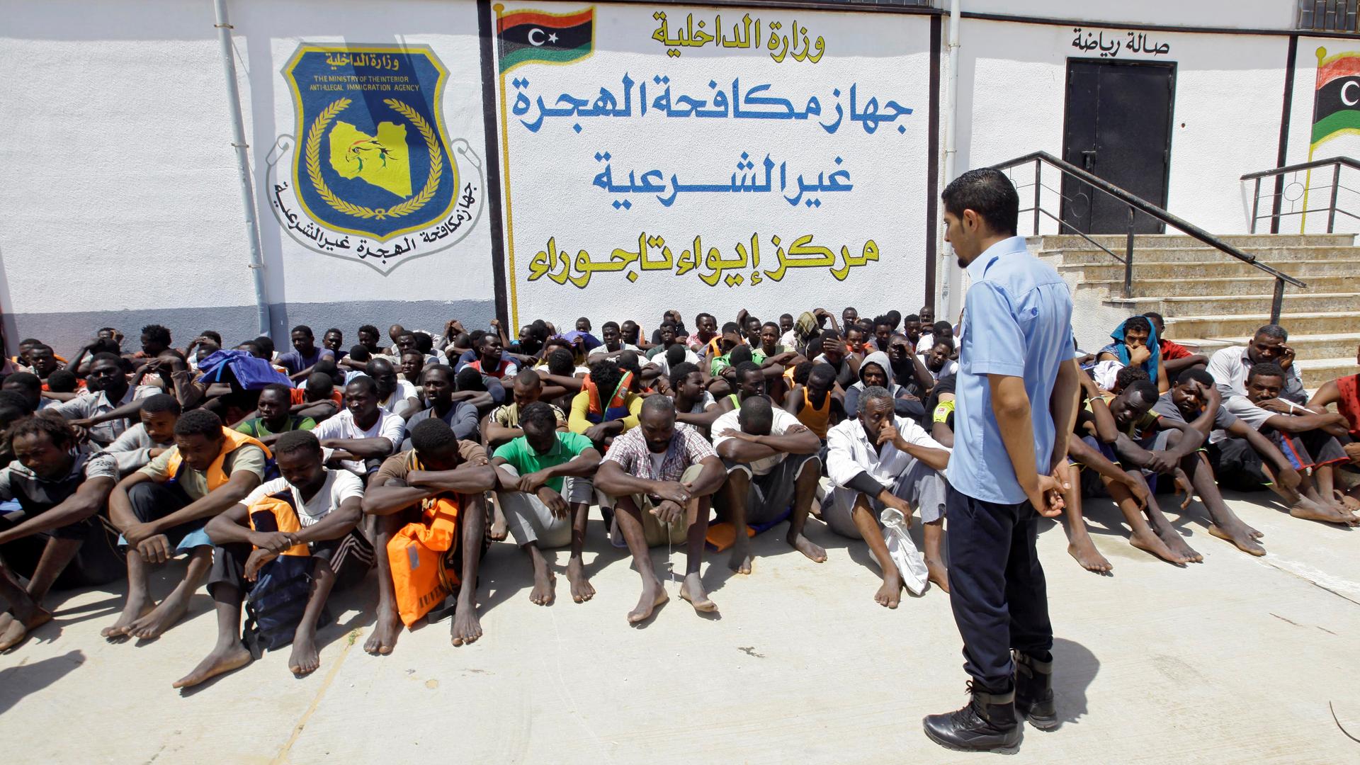 Detained migrants sit at a makeshift detention facility at Tajoura, Libya, earlier this month 