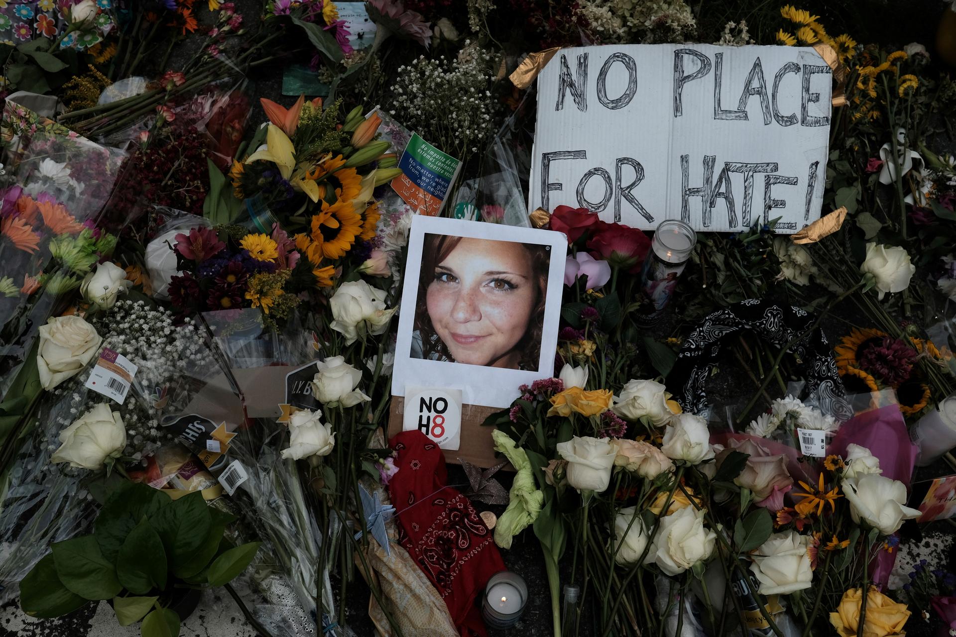 A photograph of Charlottesville victim Heather Heyer is seen amongst flowers left at the scene of the car attack on a group of counter-protesters that took her life during the "Unite the Right" rally in Charlottesville, Virginia, August 14, 2017.