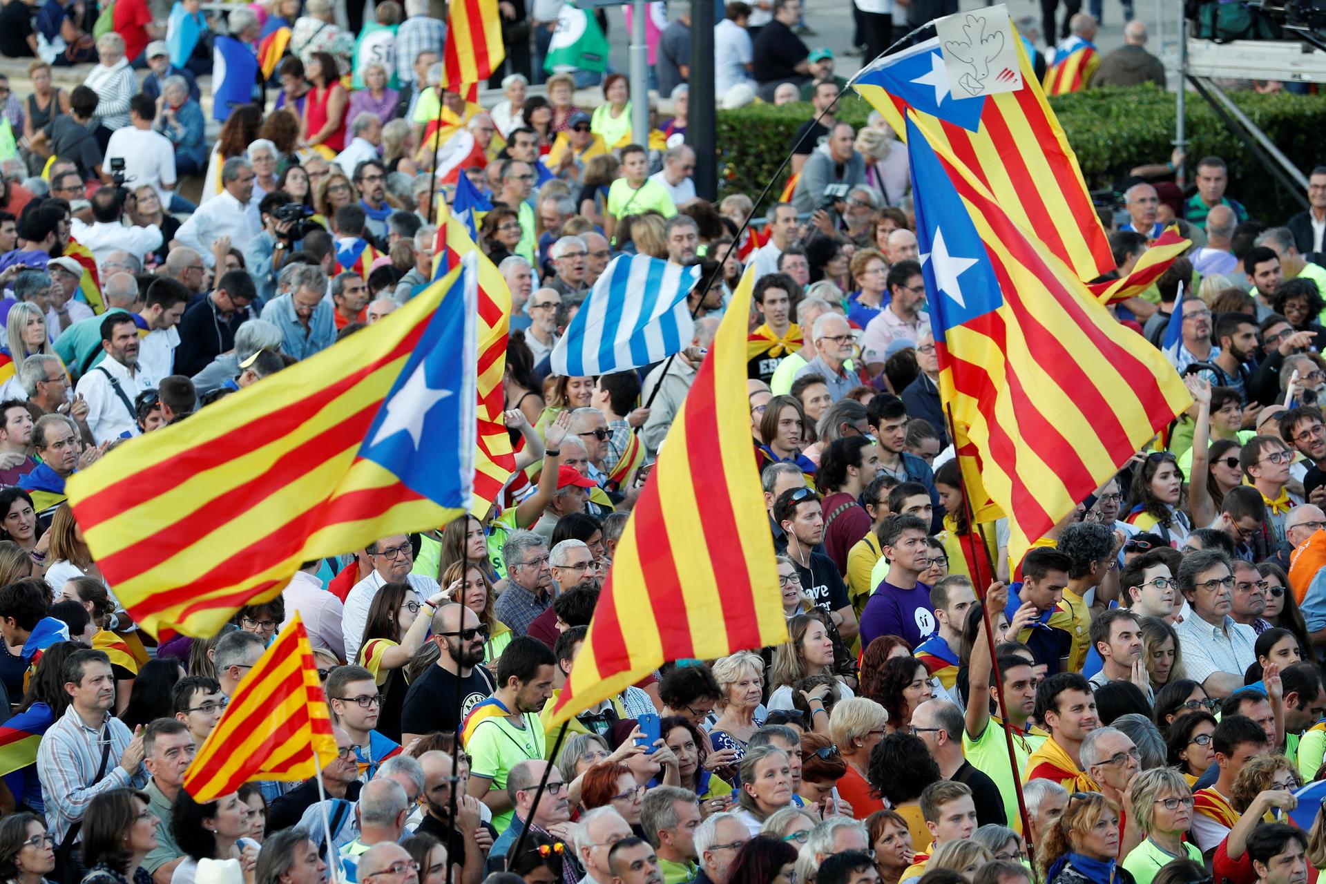 People hold Esteladas (Catalan separatist flags) as they wait for a closing rally in favour of the banned October 1 independence referendum in Barcelona, Spain.