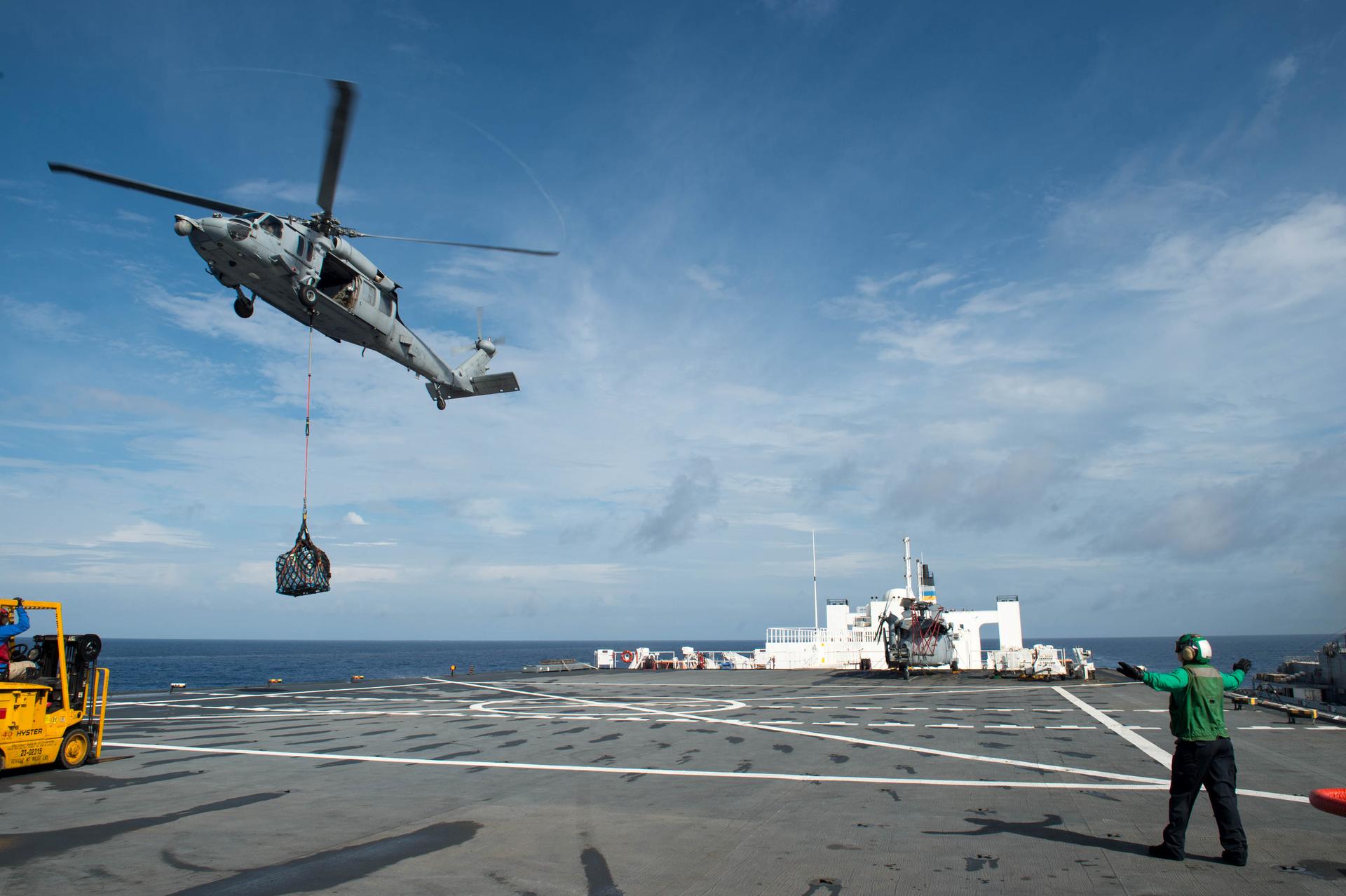 An MH-60S Sea Hawk helicopter delivers cargo to the hospital ship USNS Comfort as the ship is underway in support of humanitarian relief operations to help those affected by Hurricane Maria in Puerto Rico on October 1, 2017.
