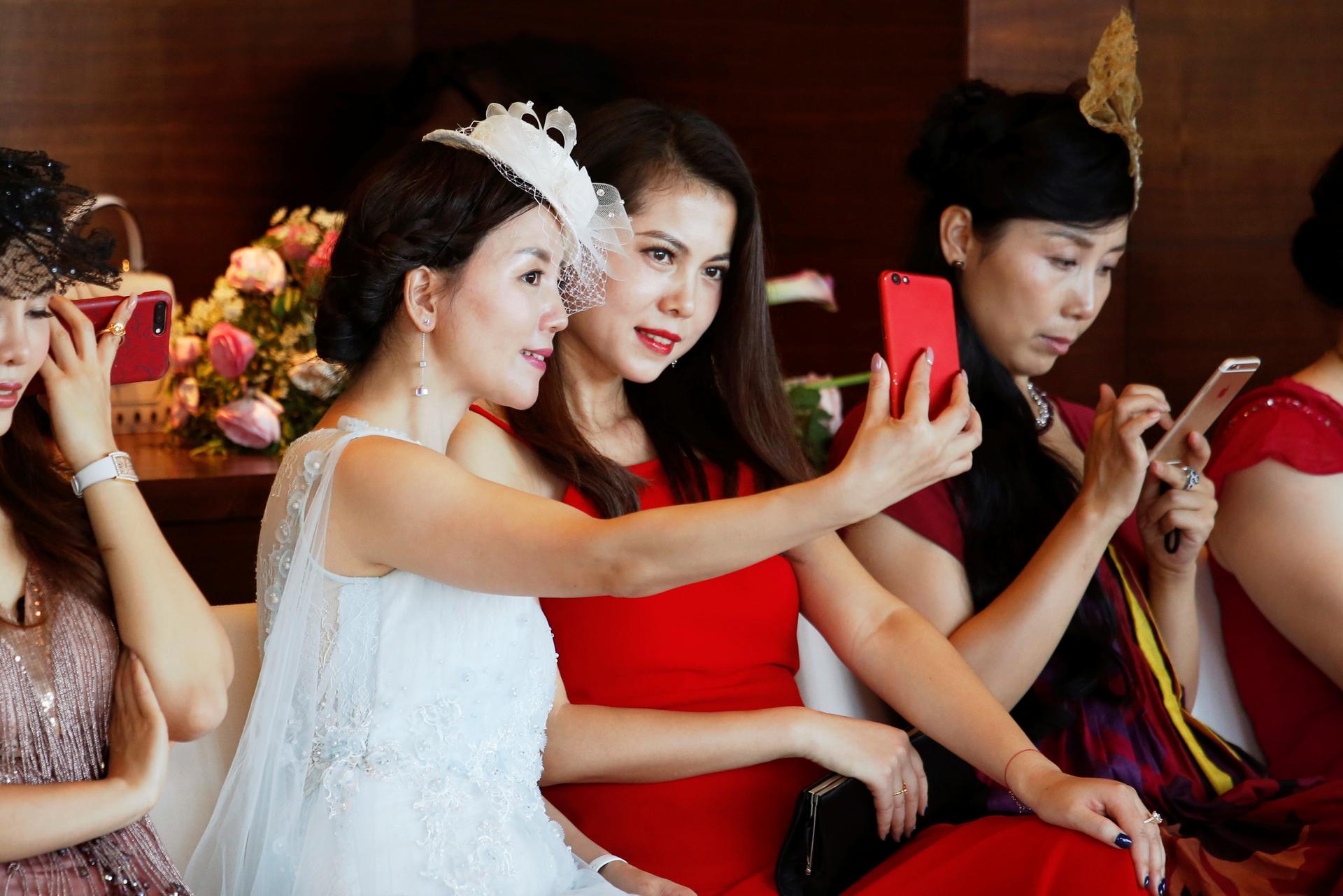 Participants take a selfie during an etiquette class by former Australian model June Dally-Watkins in Guangzhou, China October 8, 2017.