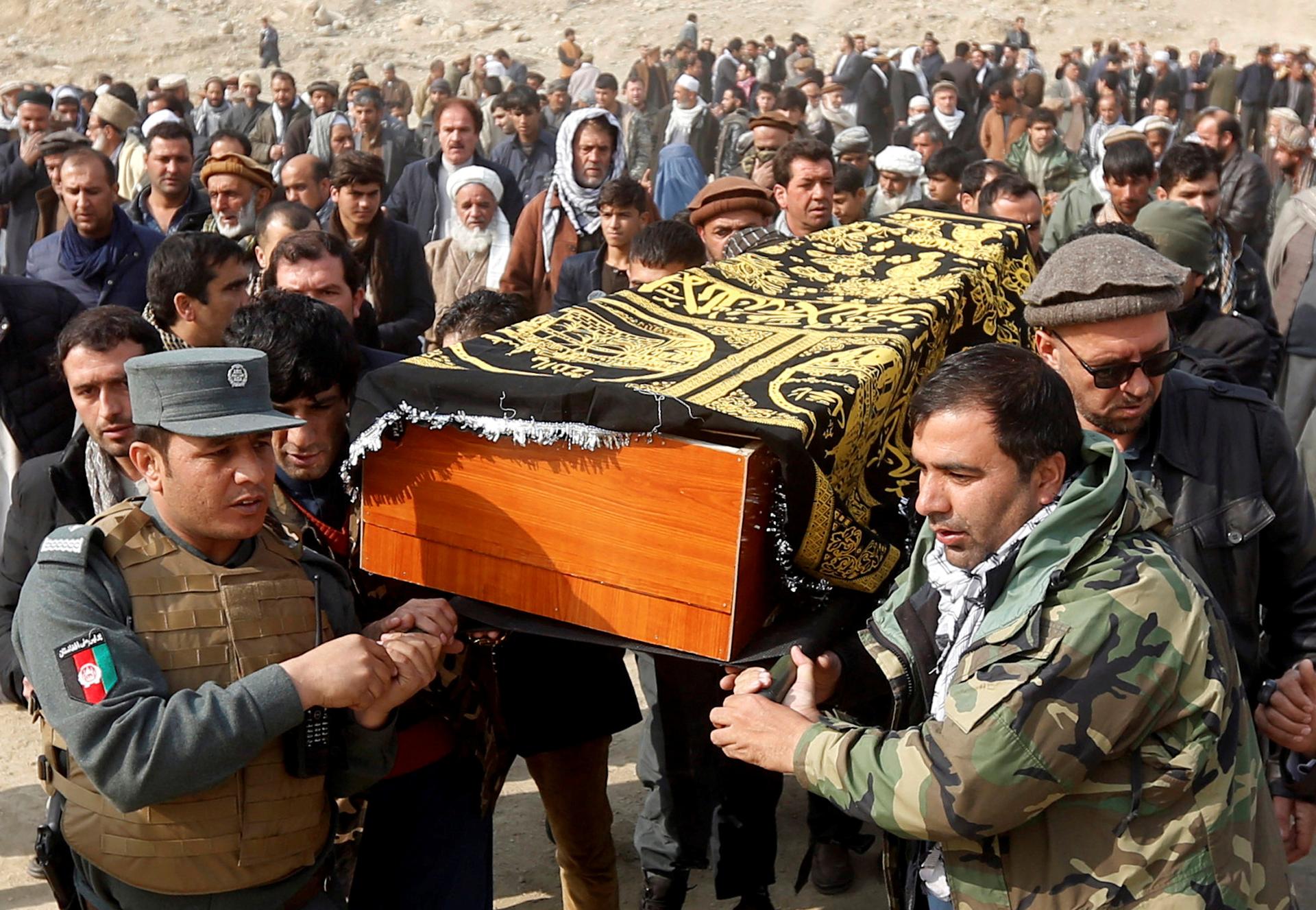 Afghan men carry the coffin of one of the victims of a car bomb attack in Kabul, Afghanistan January 28, 2018.