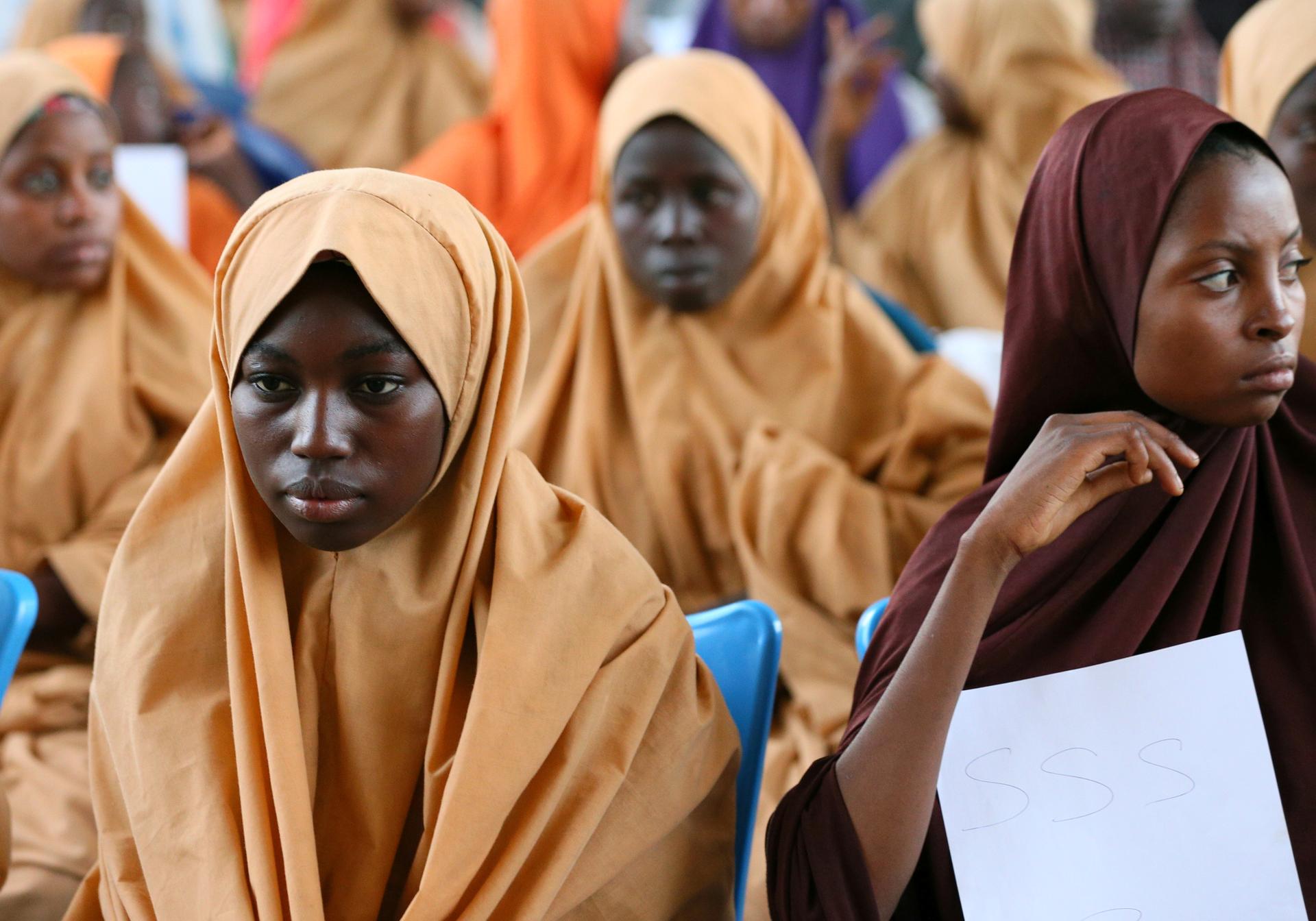 Some of the newly-released Dapchi schoolgirls wait to board a plane at the air force base in Maiduguri. 