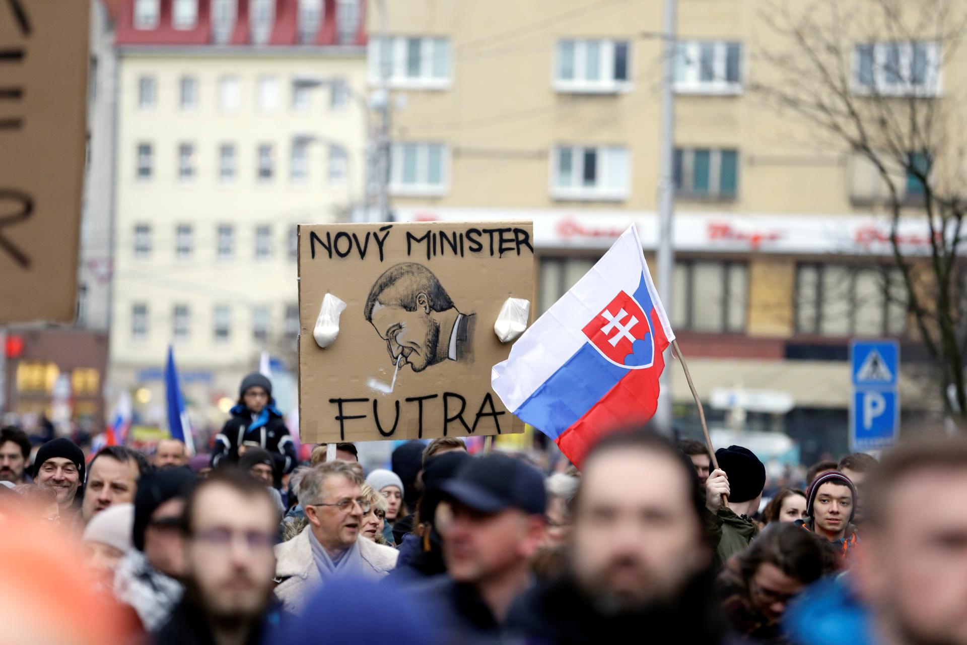 People hold up a cartoon of the new Slovak Prime Minister Peter Pellegrini during a march in Slovakia