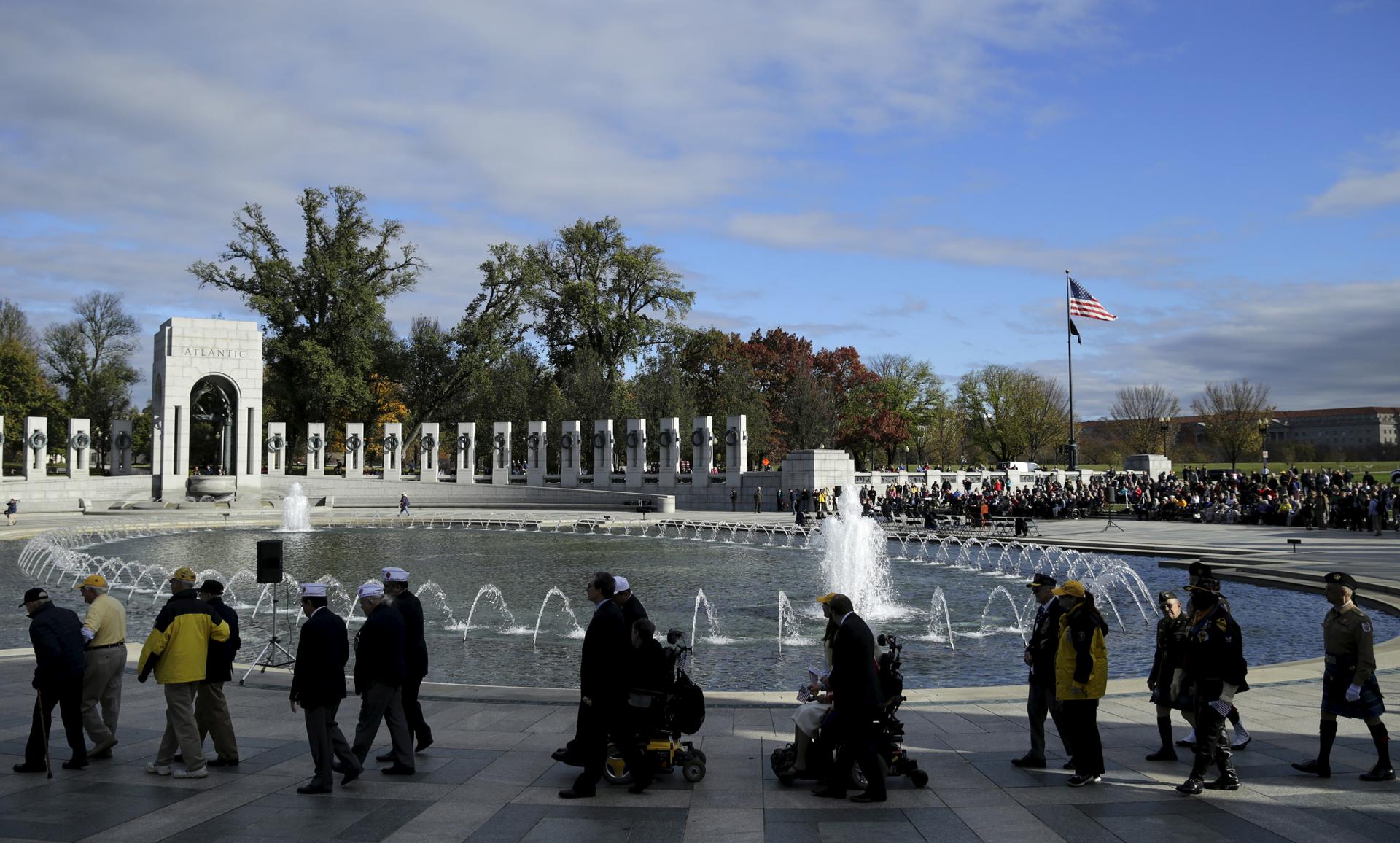 World War II veterans walk to a wreath laying ceremony at the National World War II Memorial on Veteran's Day to pay tribute to the more than 16 million men and women who served with U.S. armed forces during World War II.