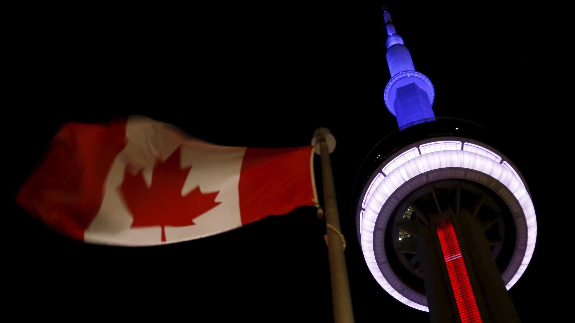 The landmark CN Tower is lit blue, white and red in the colors of the French flag following Paris attacks, in Toronto November 13, 2015.