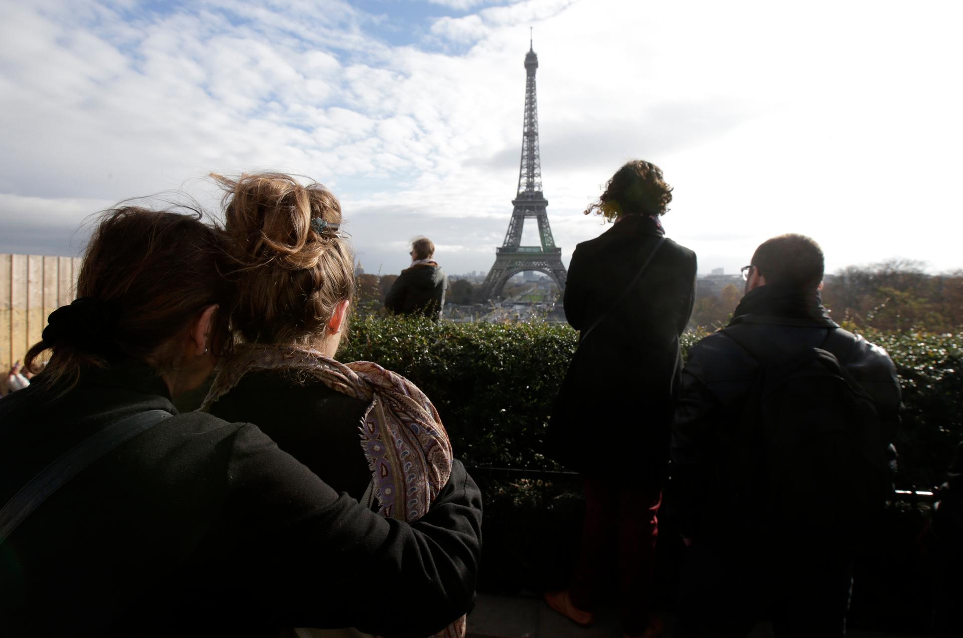 People observe a minute of silence at the Trocadero in front the Eiffel Tower to pay tribute to the victims of the series of deadly attacks on Friday in Paris, France, November 16, 2015.
