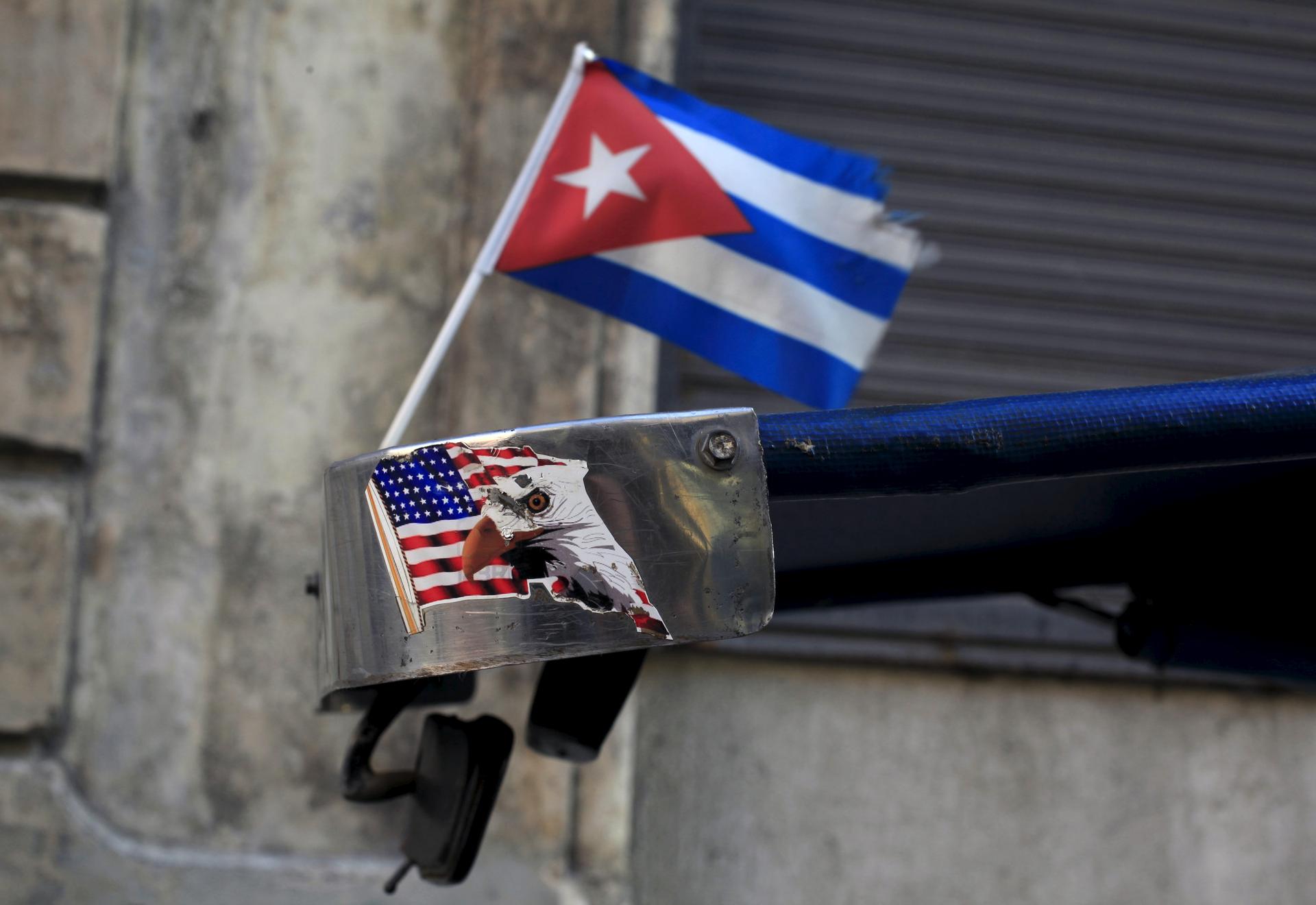 A Cuban flag and a sticker of a U.S. flag are seen on the roof of tricycle taxi in Havana March 9, 2016.