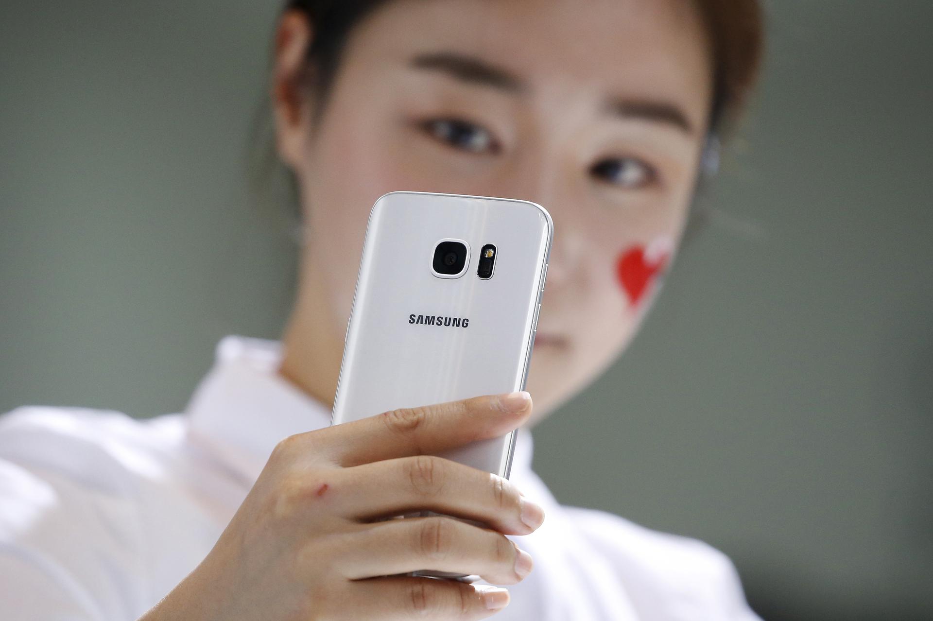 A model demonstrates a Samsung Electronics' new smartphone Galaxy S7 during its launching ceremony.