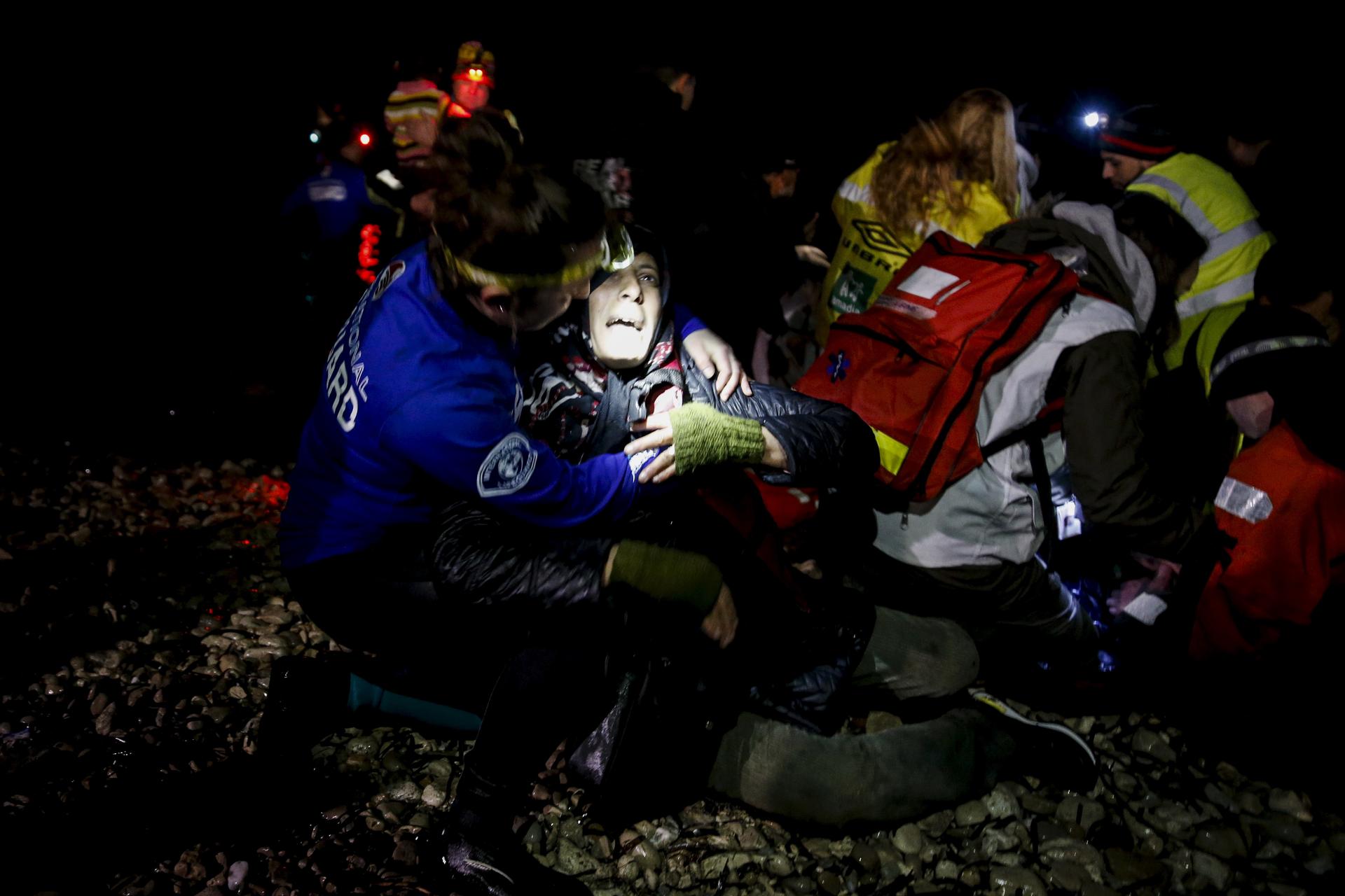 Rescuers try to revive an unconscious refugee who arrived on a dinghy on the Greek island of Lesbos. Two unconscious arrivals were taken to a hospital and were later pronounced dead.