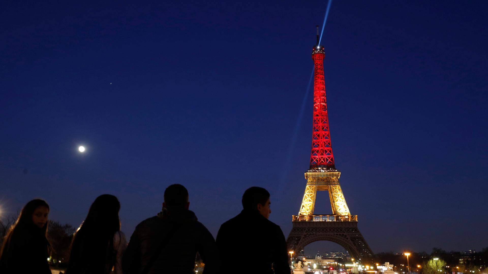 The Eiffel Tower is seen with the black, yellow and red colours of the Belgian flag in tribute to the victims of today's Brussels bomb attacks, in Paris, France, March 22, 2016.