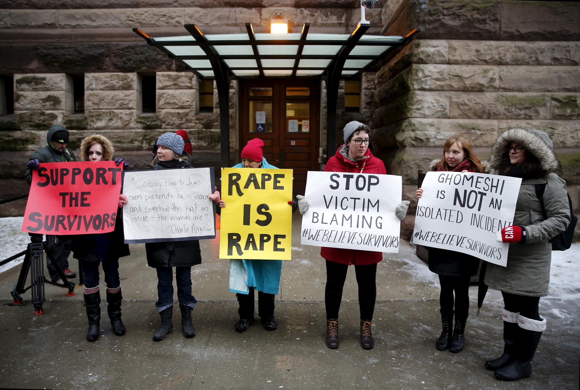 Protesters stand outside of the courthouse before an Ontario judge found former Canadian radio host Jian Ghomeshi not guilty on four sexual assault charges and one count of choking.
