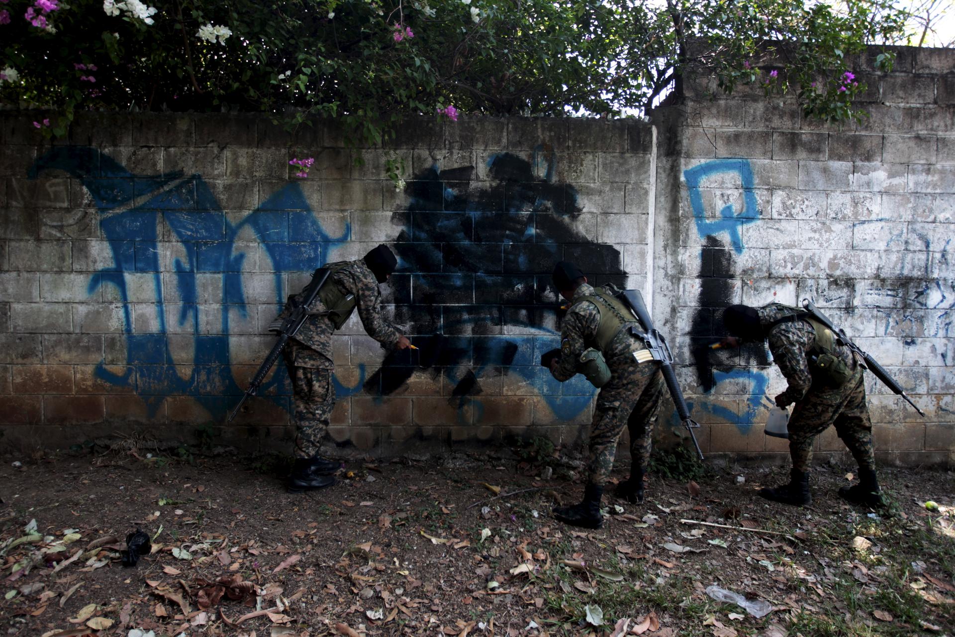 Soldiers paint over graffiti associated with the Mara Salvatrucha gang in El Rosal neighborhood in Quezaltepeque, El Salvador April 4, 2016.