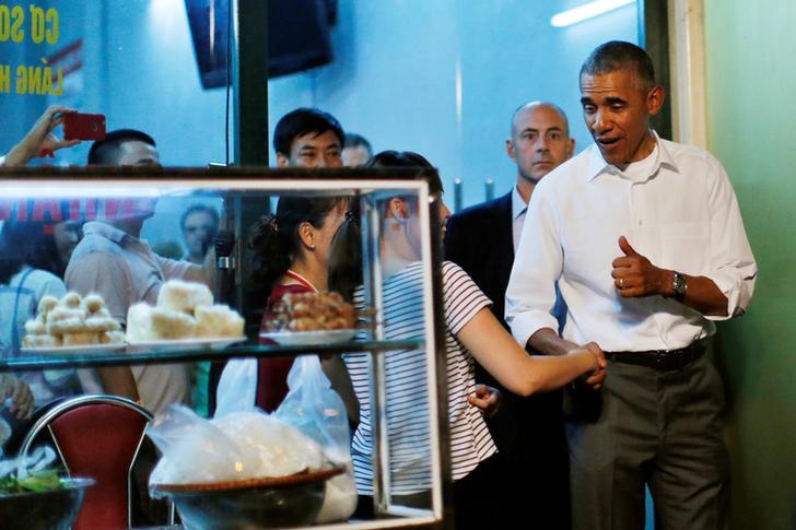 U.S. President Barack Obama shakes hands with a local resident as he leaves after having a dinner with Anthony Bourdain at a restaurant in Hanoi, Vietnam