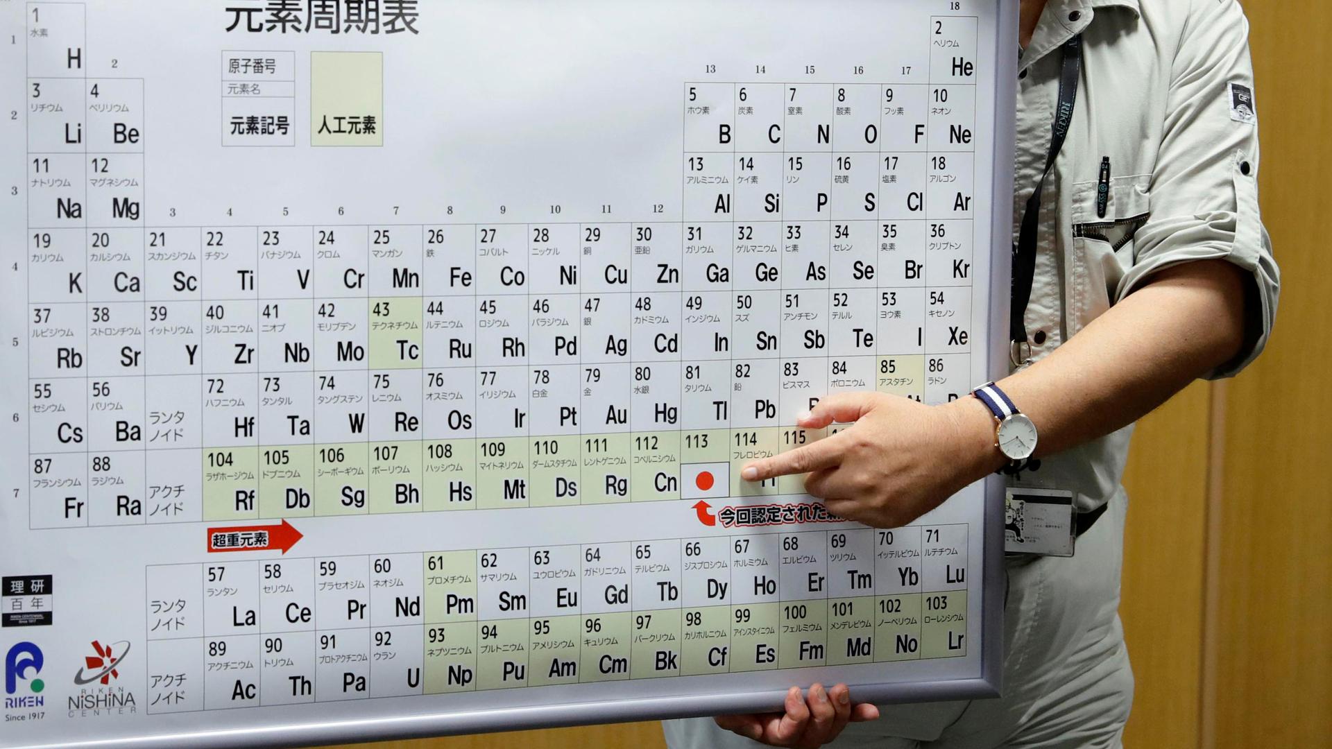 Kyushu University professor Kosuke Morita, head of a team of scientists who discovered element 113, points to the superheavy synthetic element on a periodic table at a news conference at the RIKEN institute's research centre in Wako, Saitama Prefecture, J