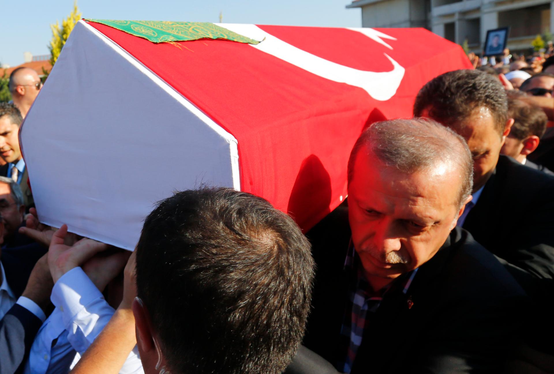 Turkish President Recep Tayyip Erdogan helps to carry a coffin with a victim of a thwarted coup following a funeral service in Istanbul, Turkey, July 17, 2016.