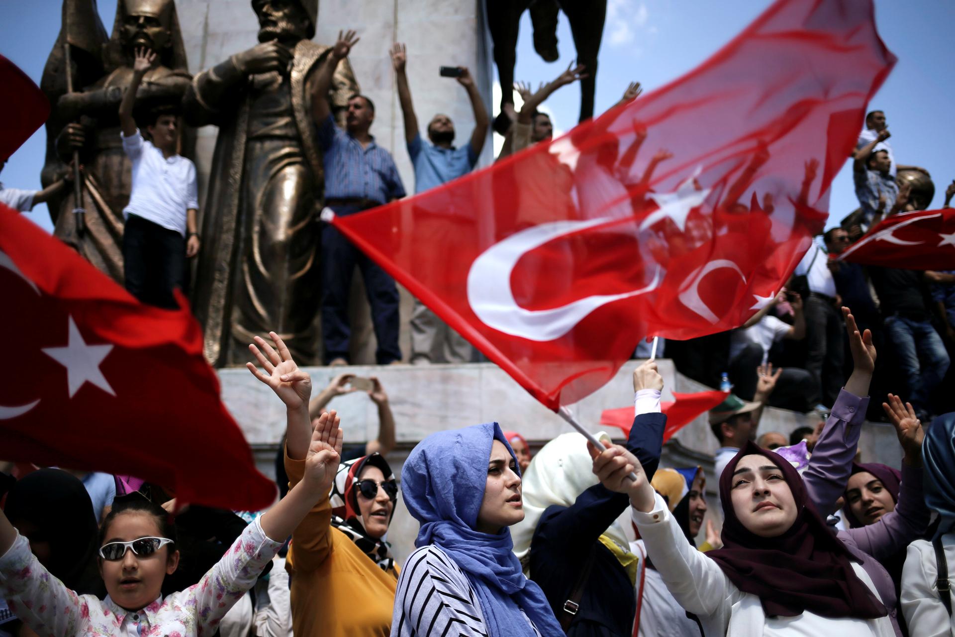 Supporters of Turkish President Tayyip Erdogan shout slogans and wave Turkish national flags during a pro-government demonstration in Sarachane park in Istanbul, Turkey, July 19, 2016.