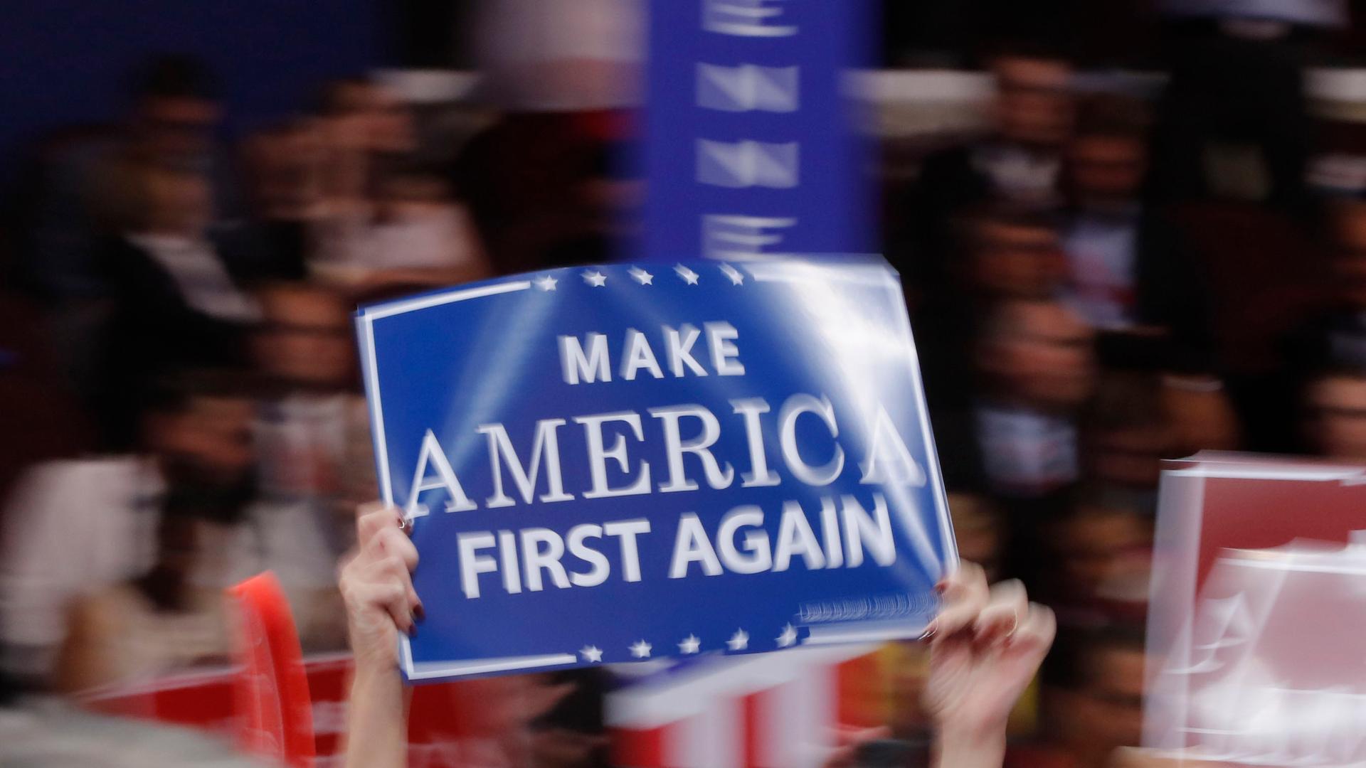 A delegate waves a "Make America First Again" sign at the Republican National Convention in Cleveland, Ohio, in July