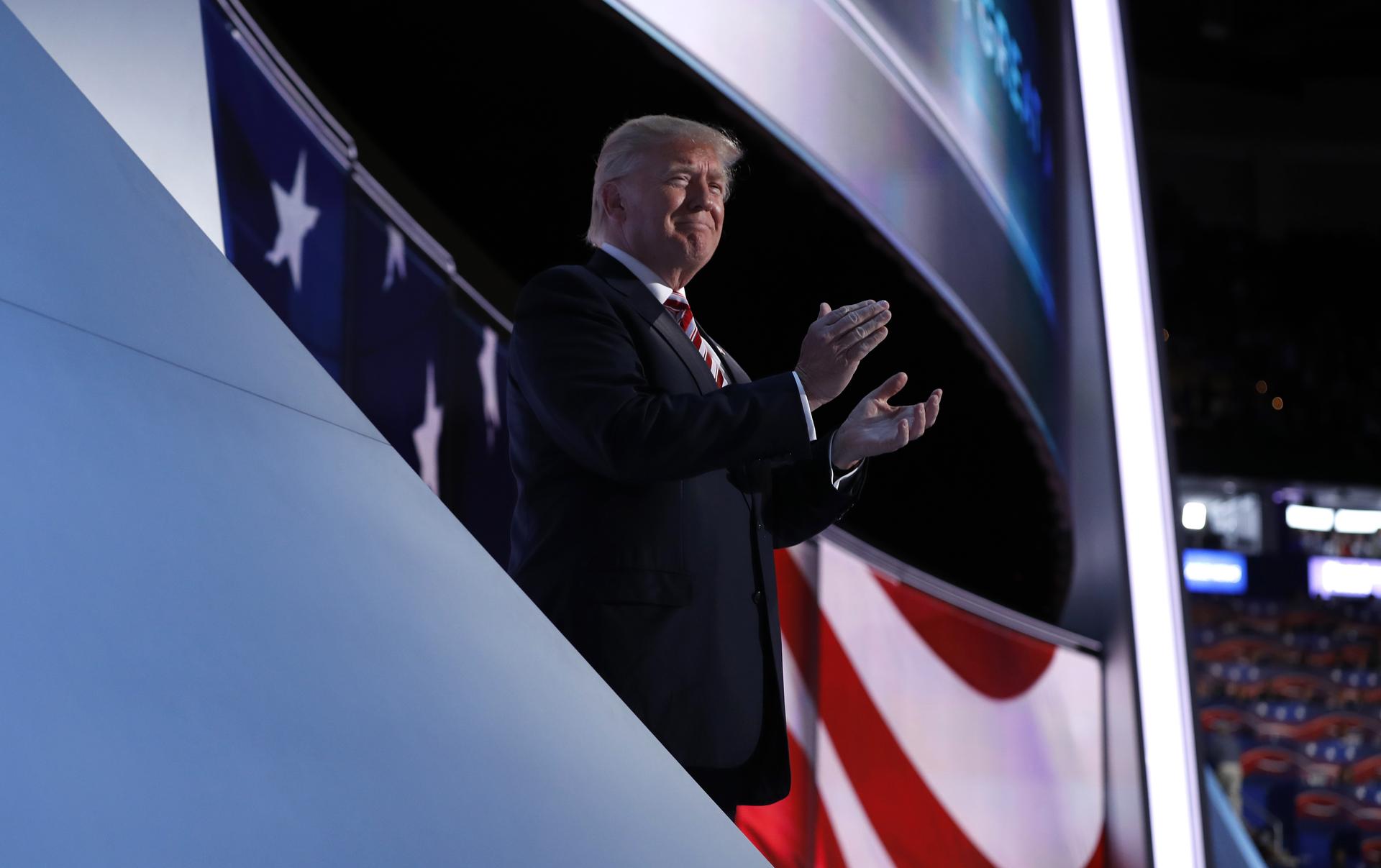 Republican U.S. presidential nominee Donald Trump applauds onstage as his running-mate Indiana Governor Mike Pence concludes his speech during the third night of the Republican National Convention in Cleveland, Ohio, U.S. July 20, 2016.