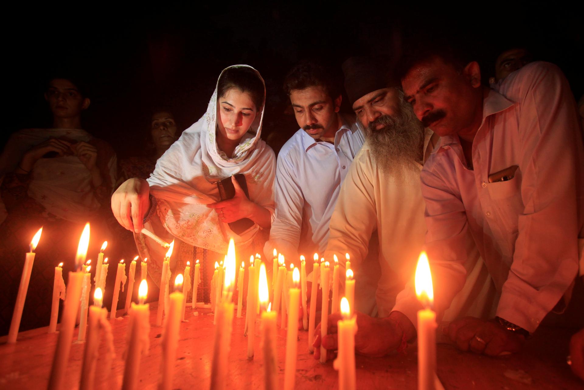 Residents light candles to honour victims of the blast in Quetta during a candellight vigil in Peshawar, Pakistan.