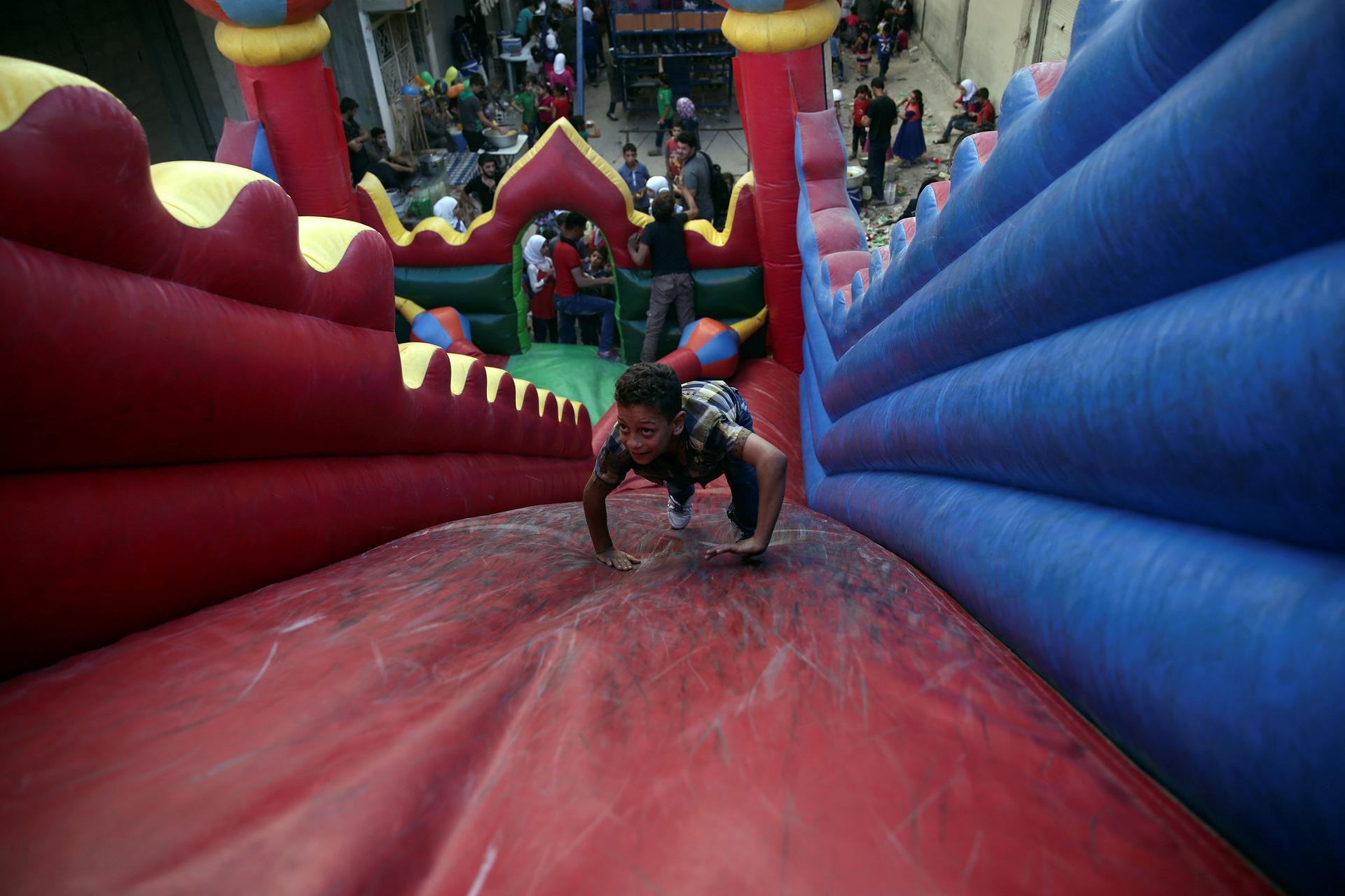 Children played on the bouncy castle on the last day of the Muslim holiday of Eid al-Adha in the rebel held besieged town of Hamouriyeh, outside of the Syrian capital of Damascus on Thursday, September 15, 2016.