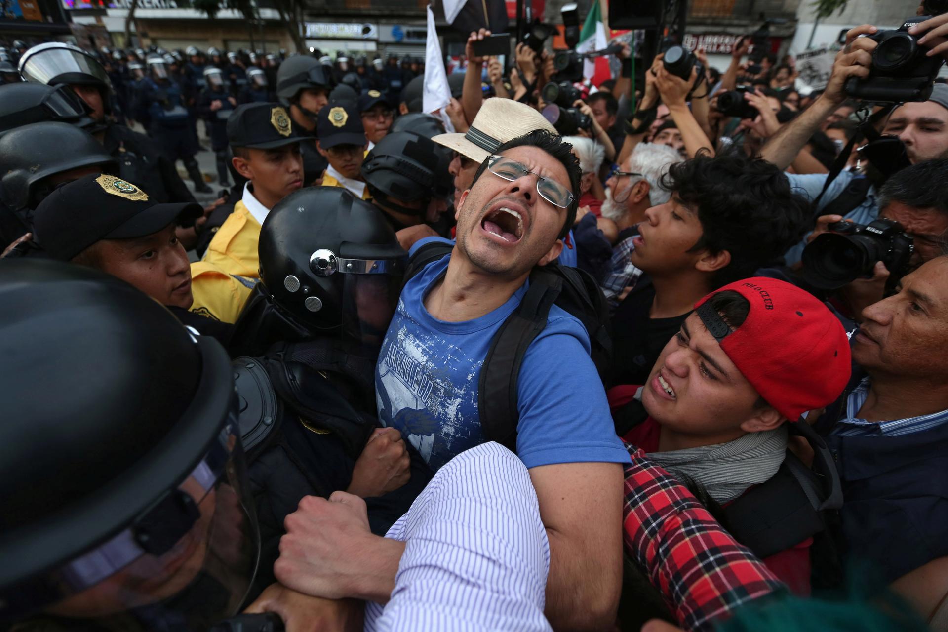 Demonstrators clash with riot police as they take part during a march demanding the resignation of President Enrique Pena Nieto in downtown Mexico City, Mexico, September 15, 2016.