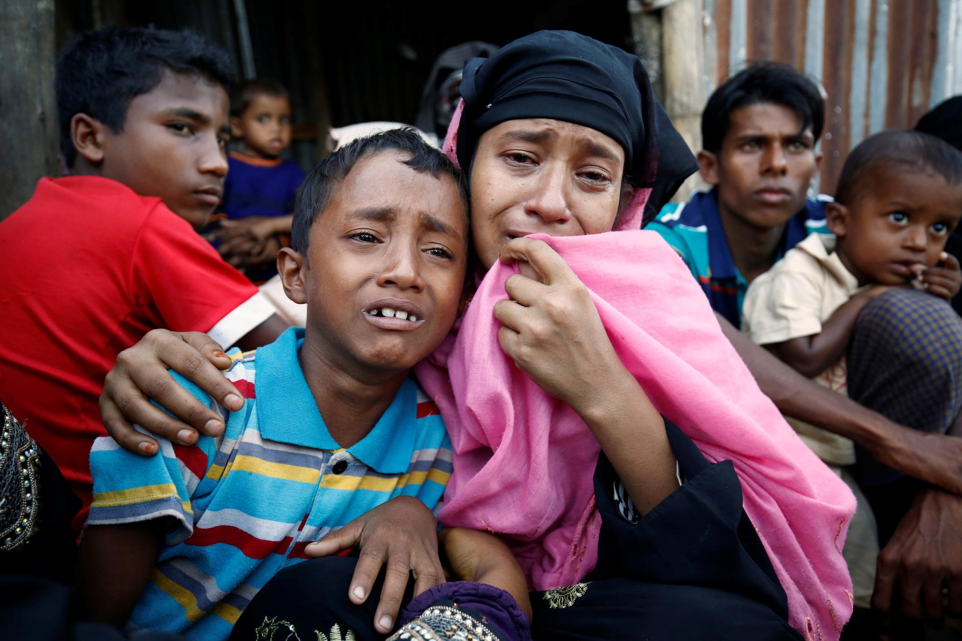 A Rohingya mother and her son weep at a border checkpoint into Bangladesh. Thousands have crossed the border to escape the violence. 
