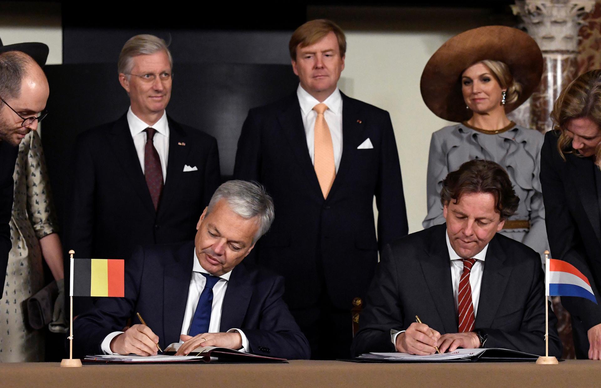 Belgian Foreign Minister Didier Reynders, left, and Dutch counterpart Bert Koenders sign a border correction treaty in Amsterdam during an official state visit to the Netherlands, on Nov. 28, 2016.