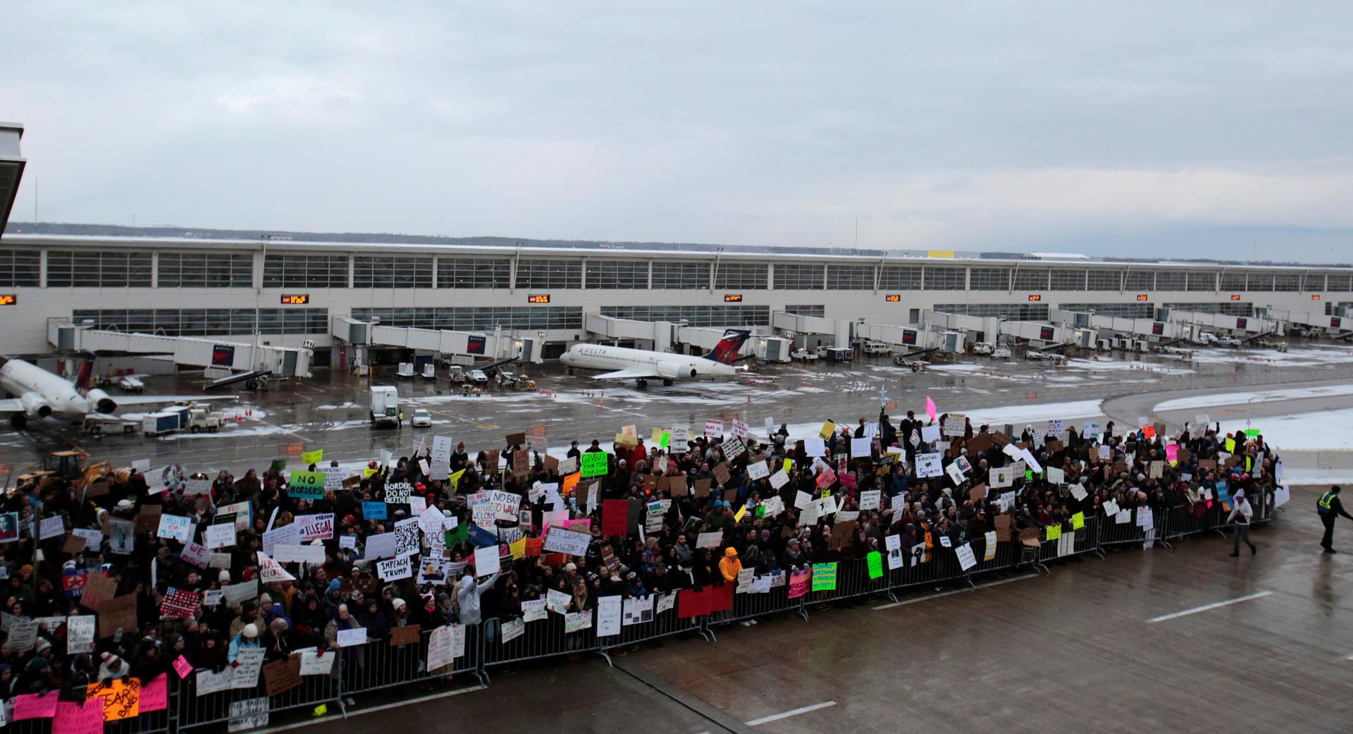 Protesters at airport, protesting outdoors in front of airplanes