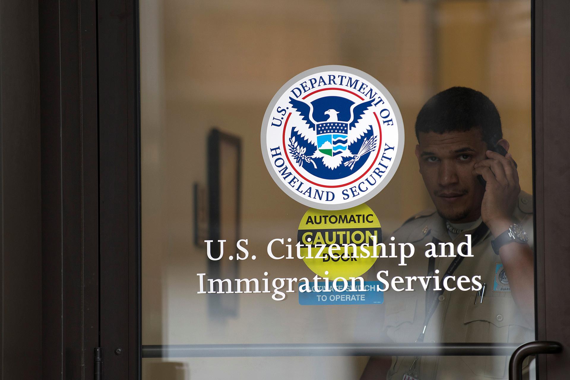 A security guard looks out of the U.S. Citizenship and Immigration Services offices in New York, U.S. on August 15, 2012.