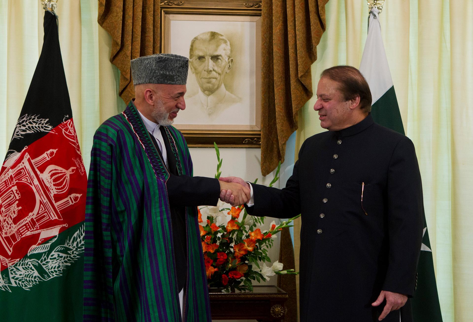 Afghan President Hamid Karzai shakes hands with Pakistan's Prime Minister Nawaz Sharif at the prime minister's residence in Islamabad