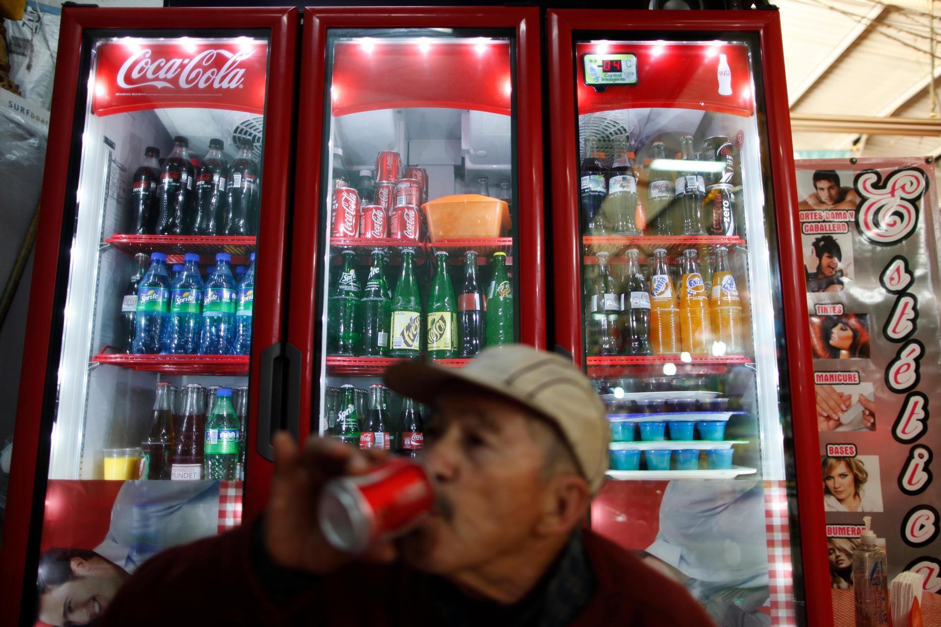 A man drinks a soft drink at a store in Mexico City. Last year, the Mexican government has imposed a 1 peso per liter tax on soda and sugary drinks to combat obesity.