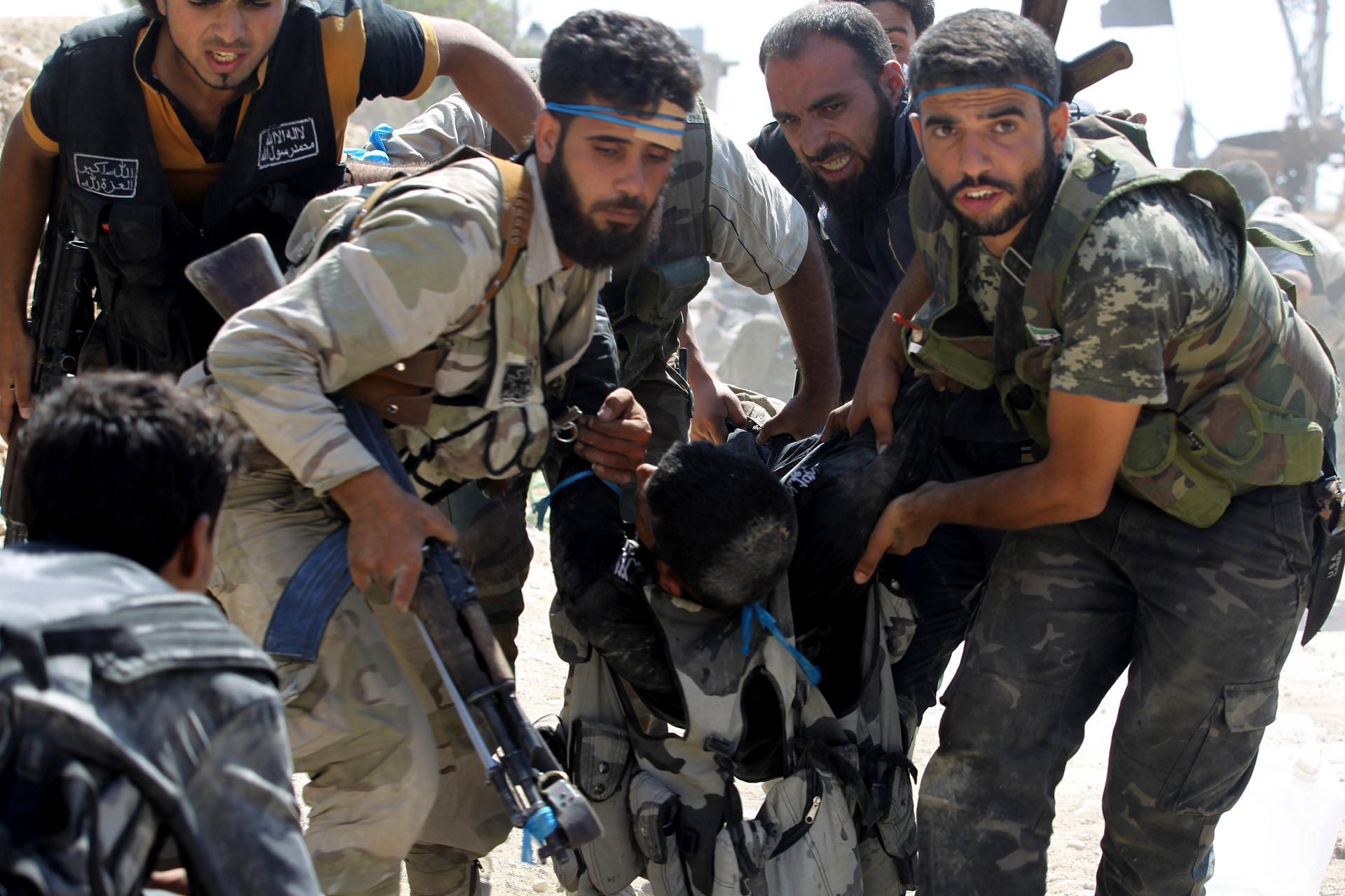 Free Syrian Army fighters carry a fellow fighter after he was wounded on the front line in Aleppo's Sheikh Saeed neighbourhood, September 21, 2013. 